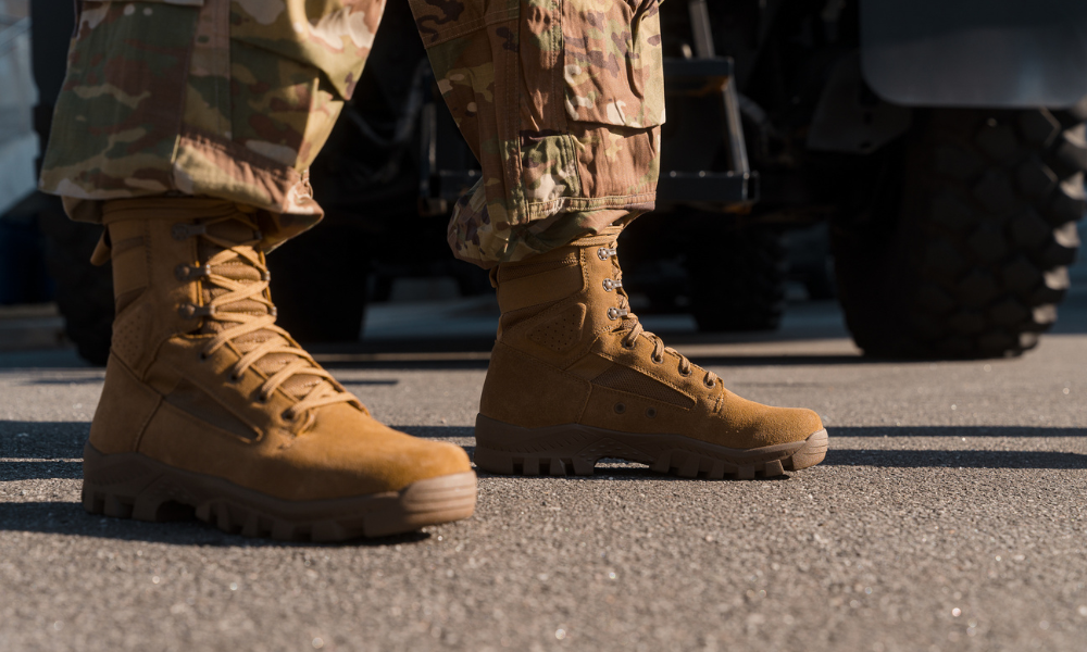 Garmont tactical boots with rugged soles worn by a military in camouflage pants, standing on asphalt near a military vehicle