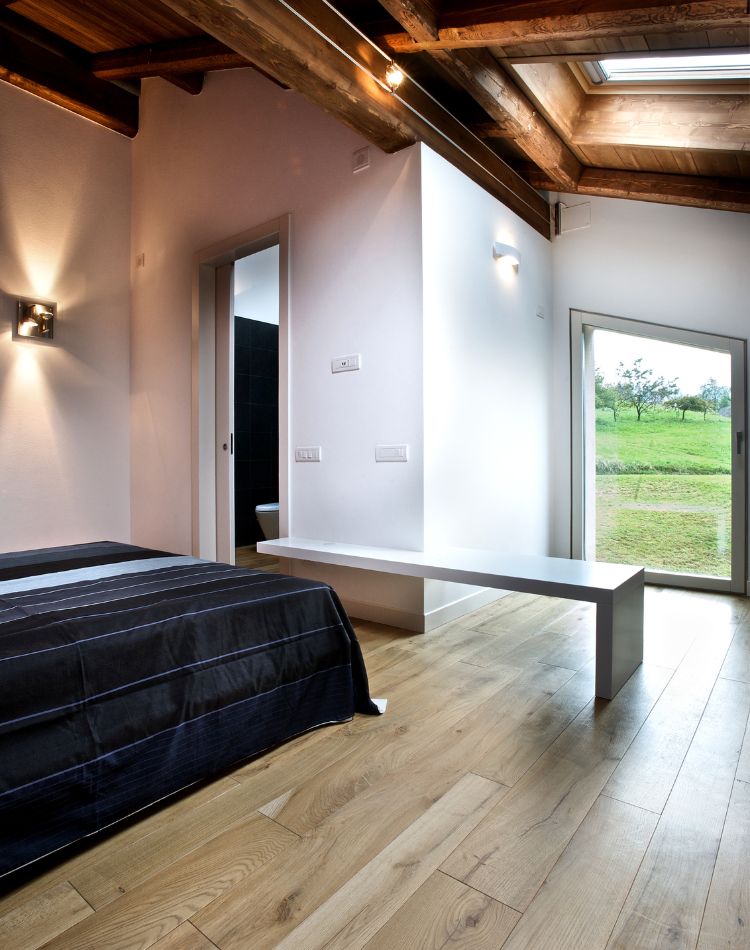 camera con pavimento in legno di rovere antico e soffitto in abete