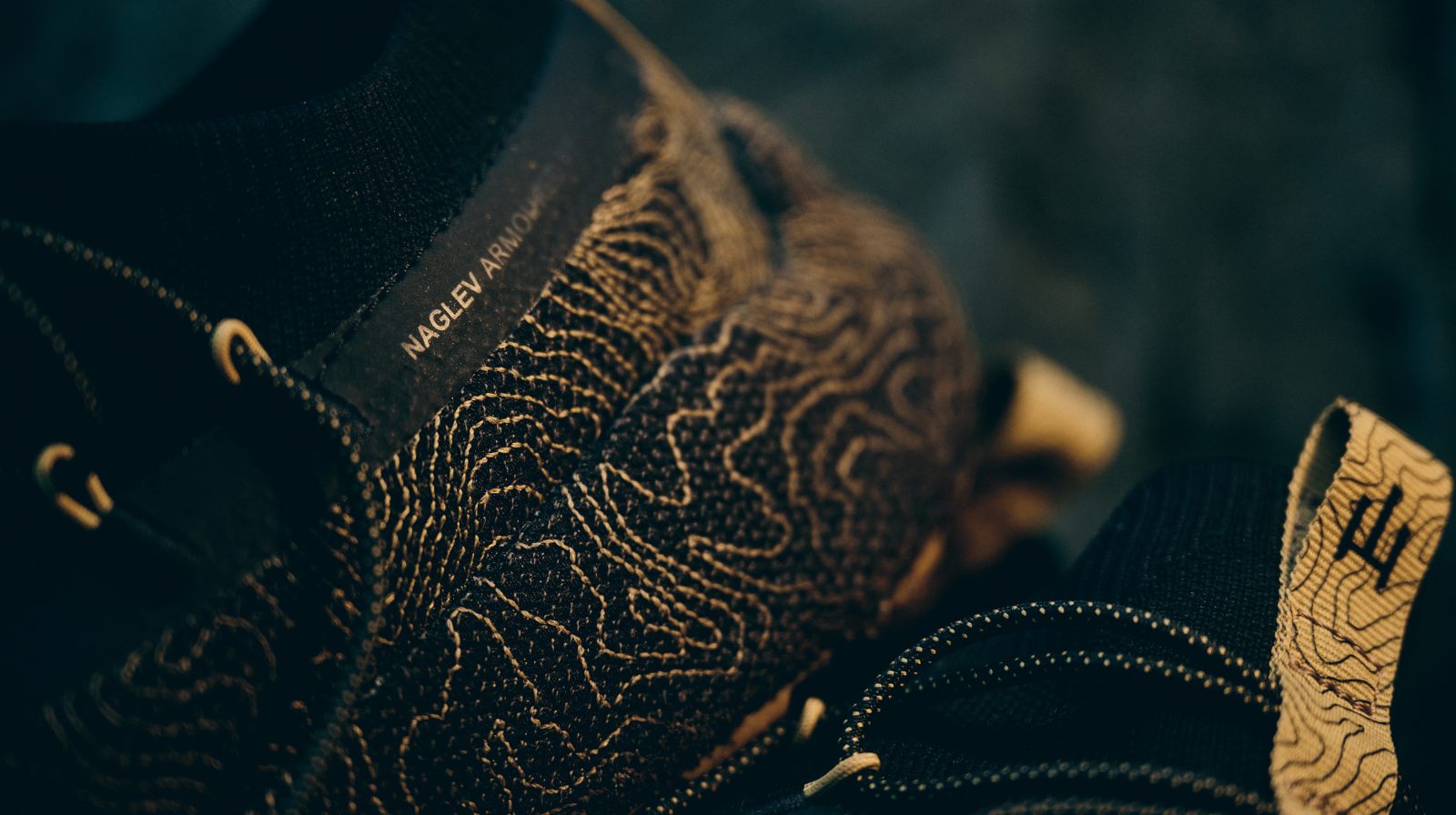 Dettaglio ravvicinato della tomaia di una scarpa Naglev con scritta ‘Naglev Armor’, realizzata in tessuto tecnico con trama topografica