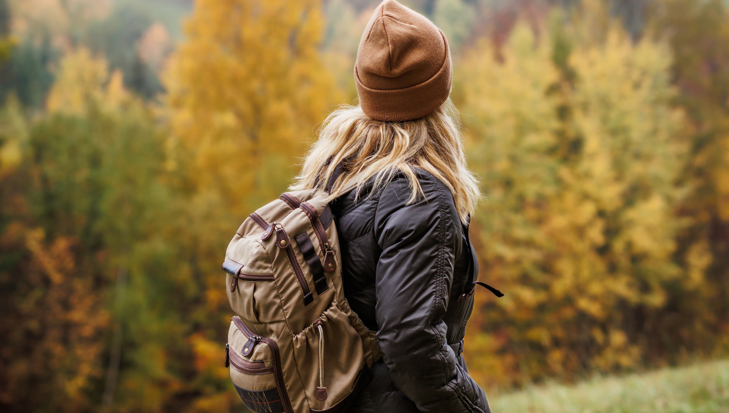 Persona con mochila observando un paisaje montañoso 