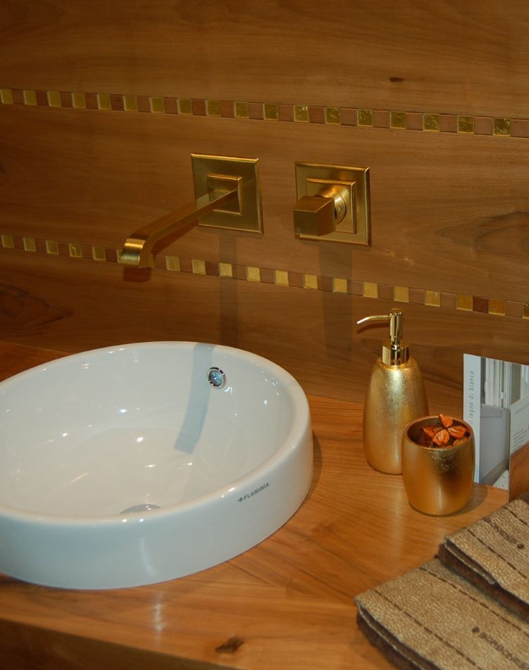 boiserie su mobiletto del bagno con lavabo in rovere e oro