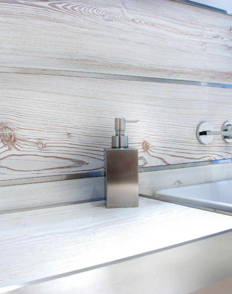 Boiserie in larice antico sbiancato realizzata con tavole di larghezza e lunghezza fissa con  inserti di acciaio inox satinato 