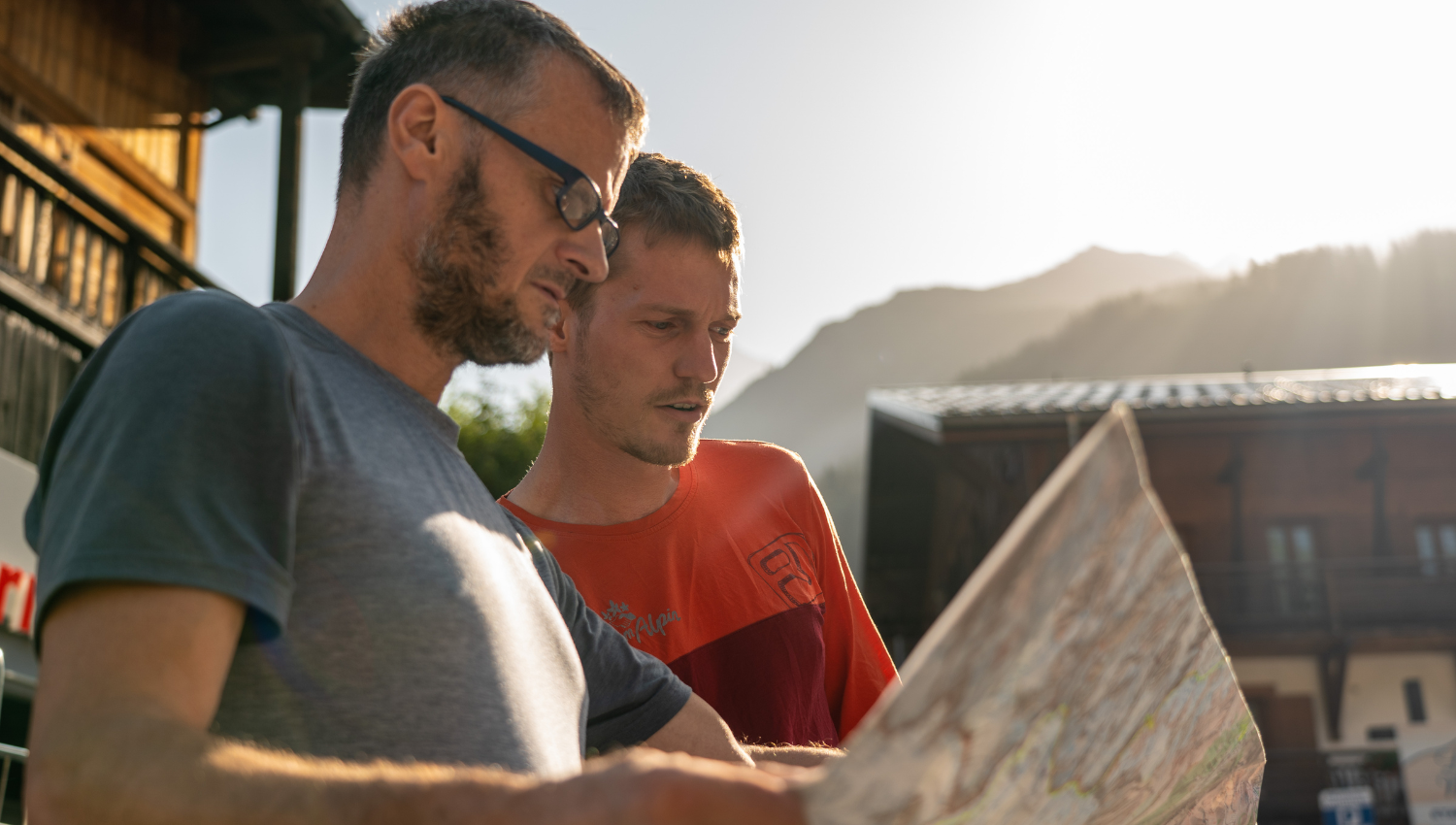 Due escursionisti che consultano una mappa topografica, durante un’escursione in montagna.