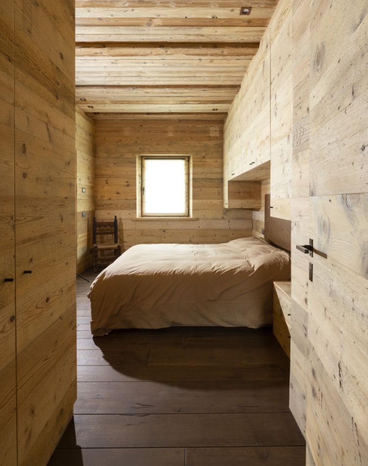 camera con rivestimenti e comodini in legno d’abete