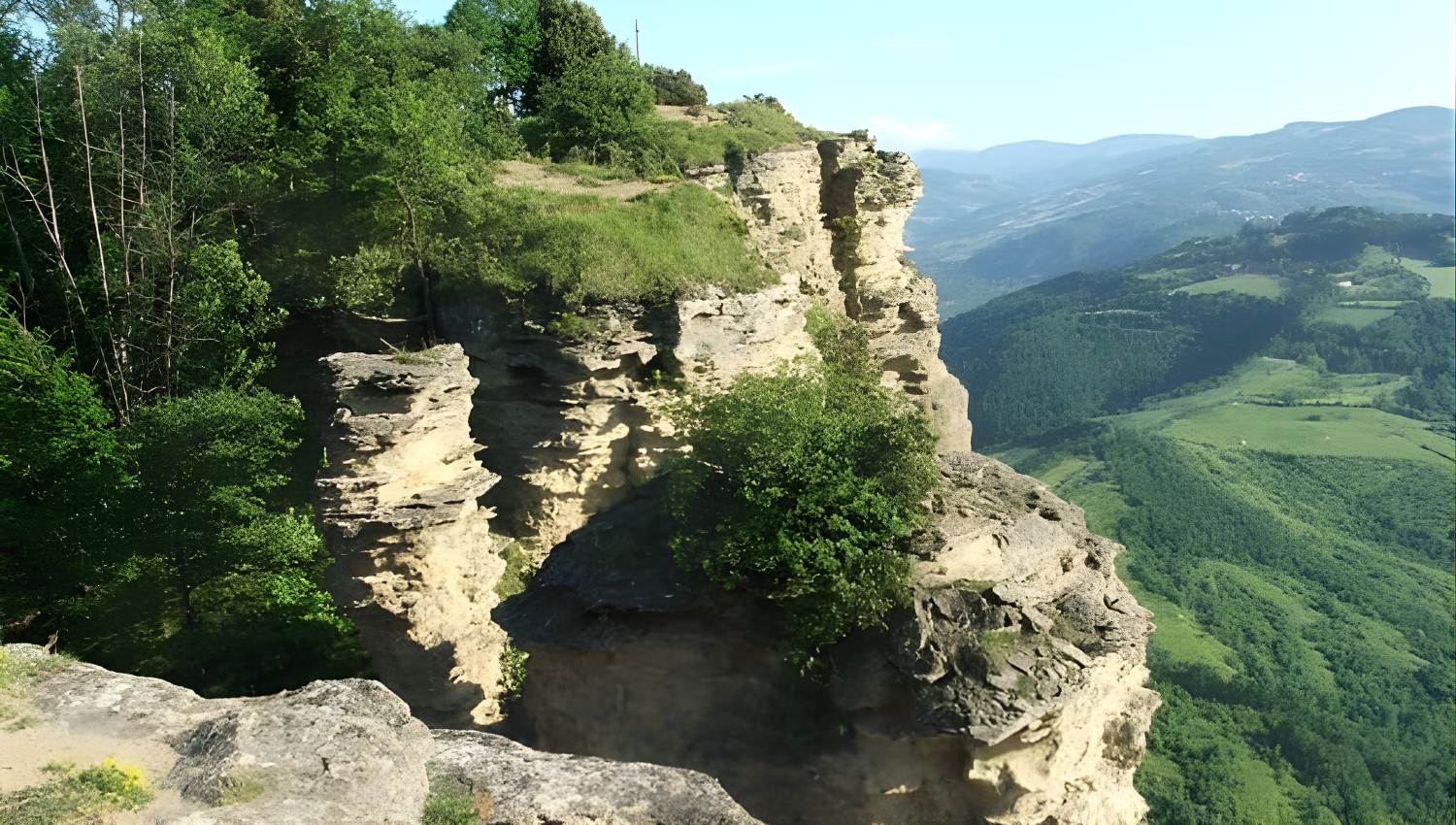 Panorama montano con spettacolari formazioni rocciose a picco, circondate da foreste e vallate verdi sulla via degli dei