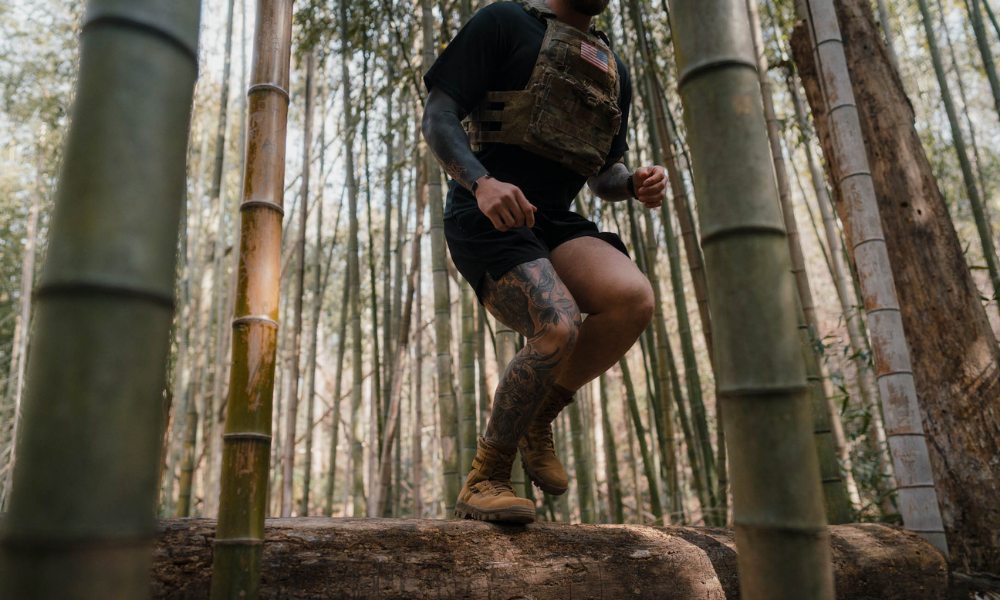 Soldier running on a log in a bamboo forest during outdoor training exercise.