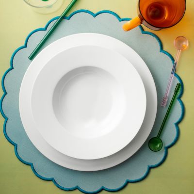 mise en place moderna con piatti bianchi e accessori colorati