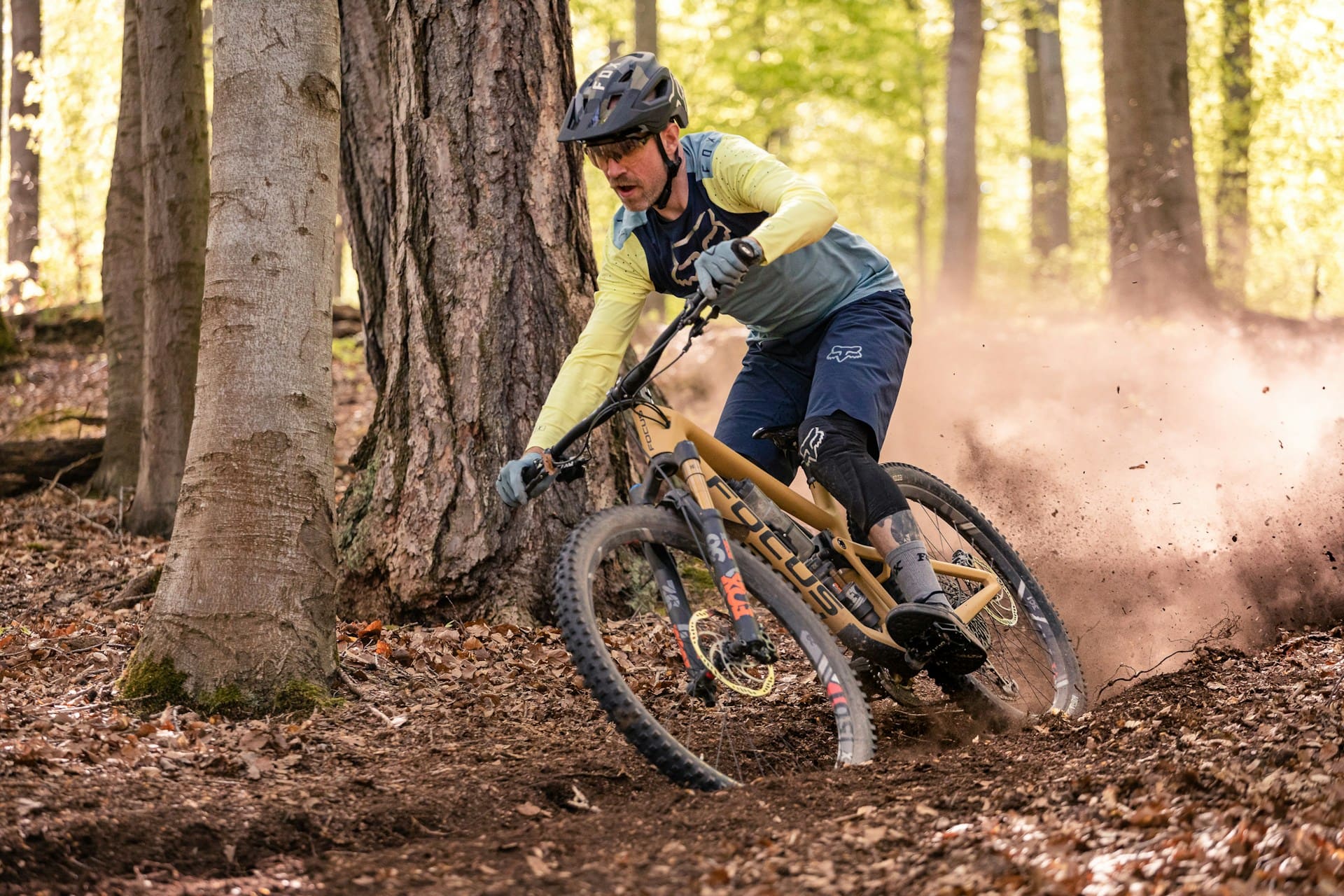 uomo in discesa nel bosco su trail bike