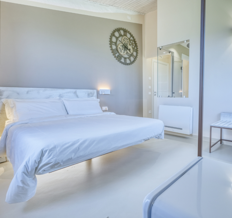 Camera Moraiolo, ampia e luminosa, con letto matrimoniale sospeso e un caratteristico orologio rustico. 