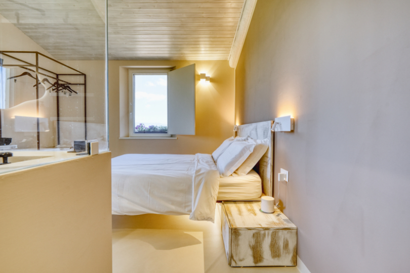 Camera Moraiolo, con letto sospeso, doppi cuscini e dettagli di design.