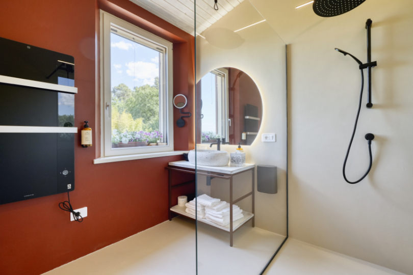 Bagno della camera Leccino, con ampia doccia walk-in, lavabo,asciugamani, saponi della linea Nuxe, moderno ed elegante impianto di riscaldamento e finestra sul verde.