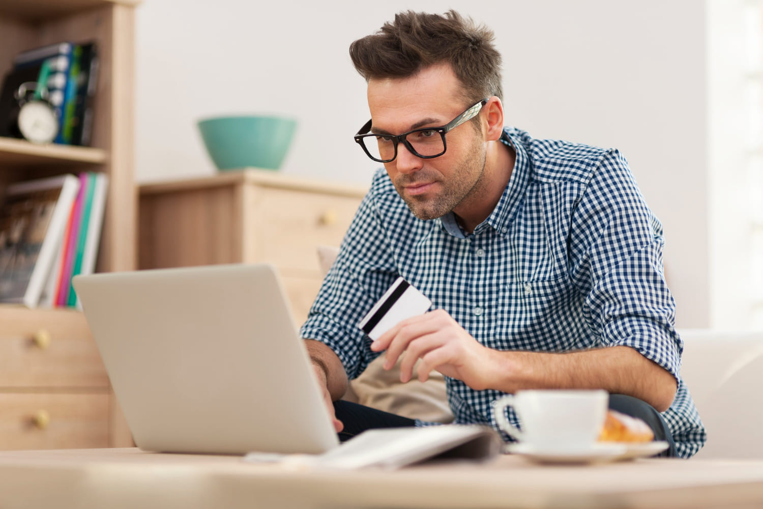 uomo con pc e carta di credito in mano