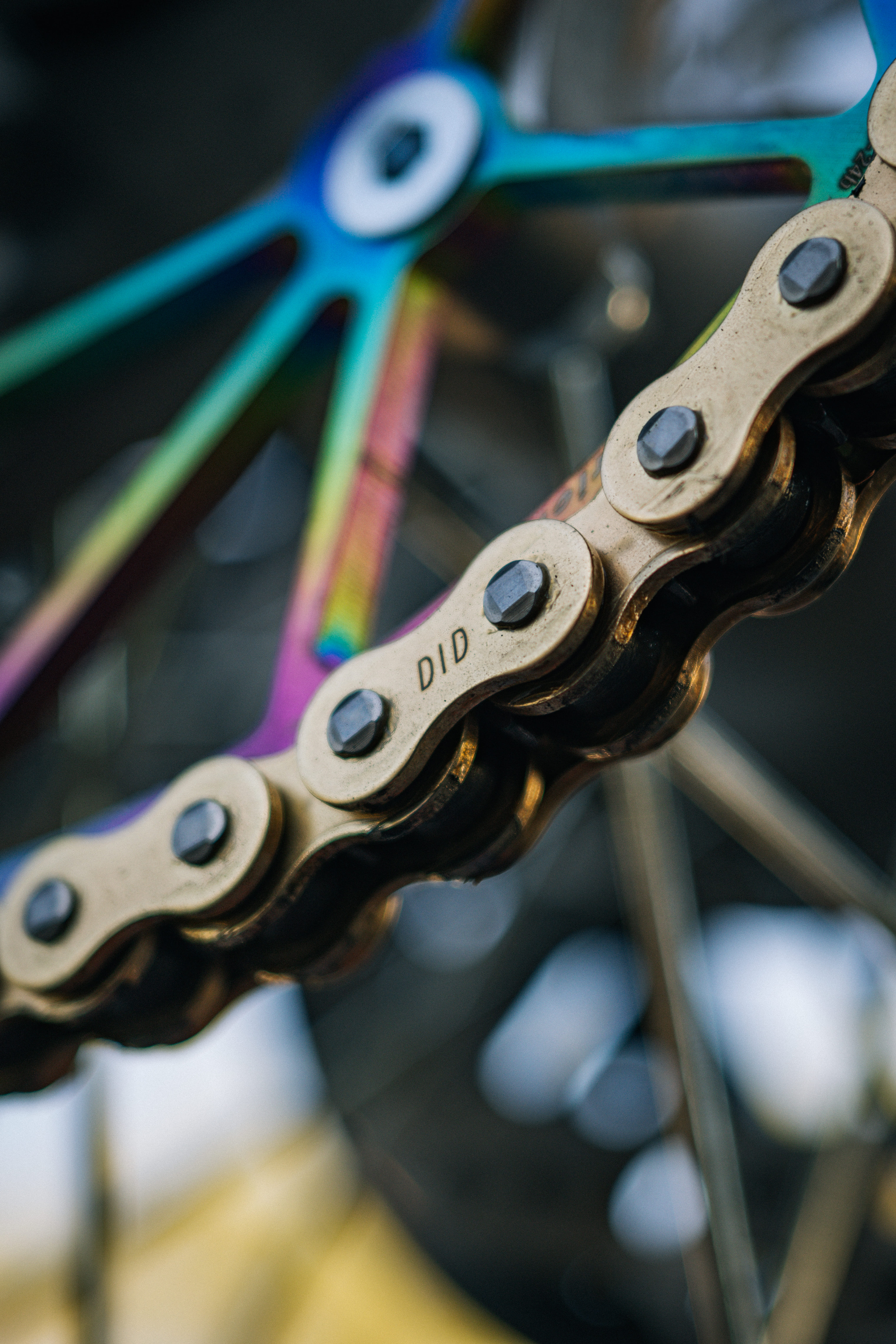 DID motorcycle chain link with sprocket in the background