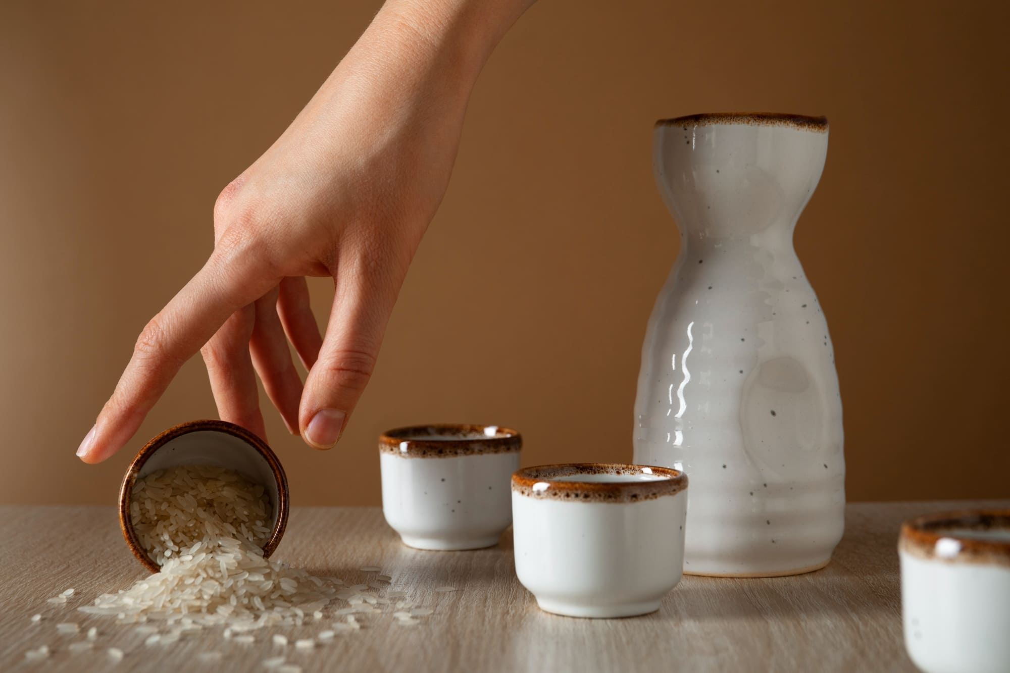 mano con tazzina di riso e set per il sake