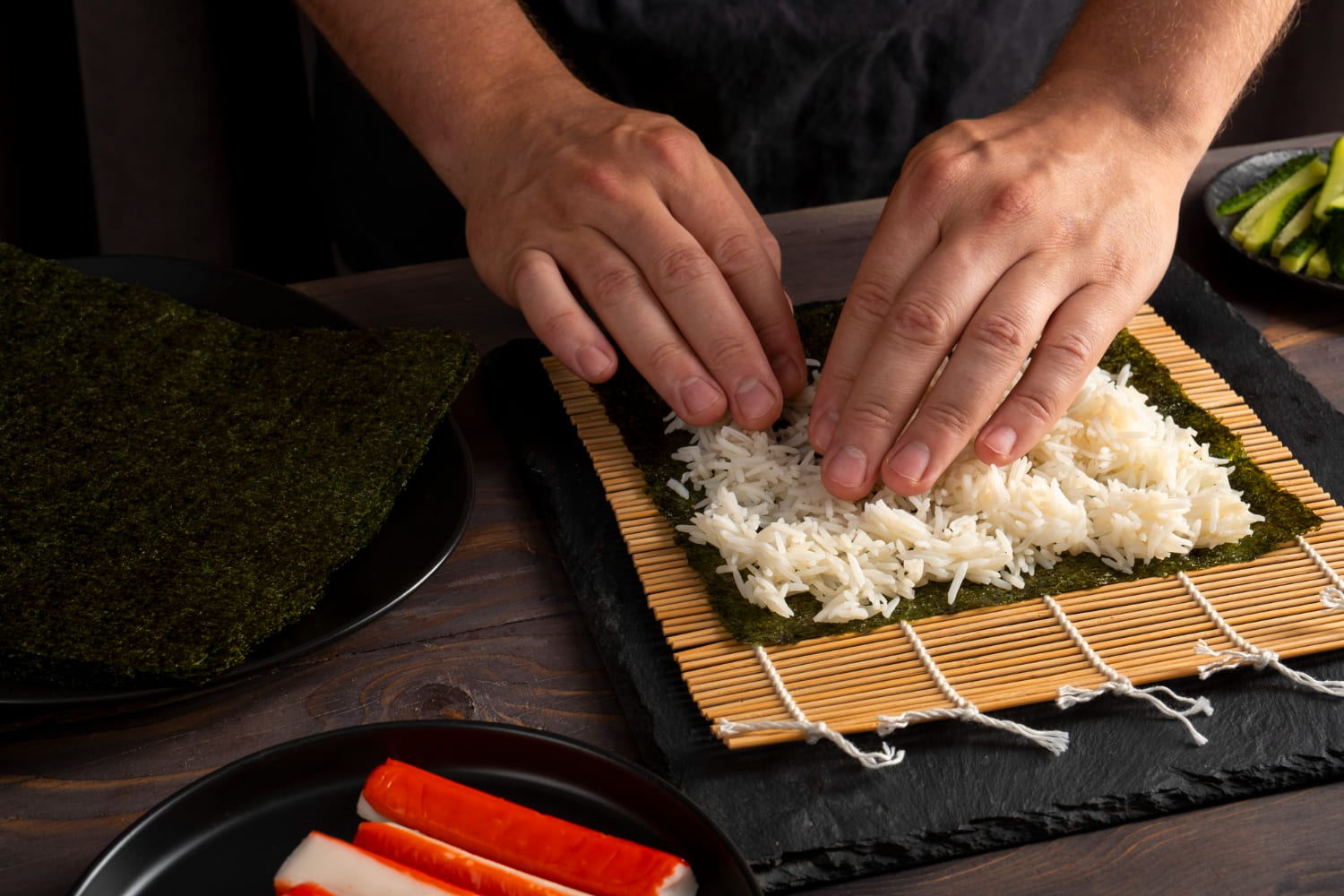 mani stendono riso sushi su alga nori