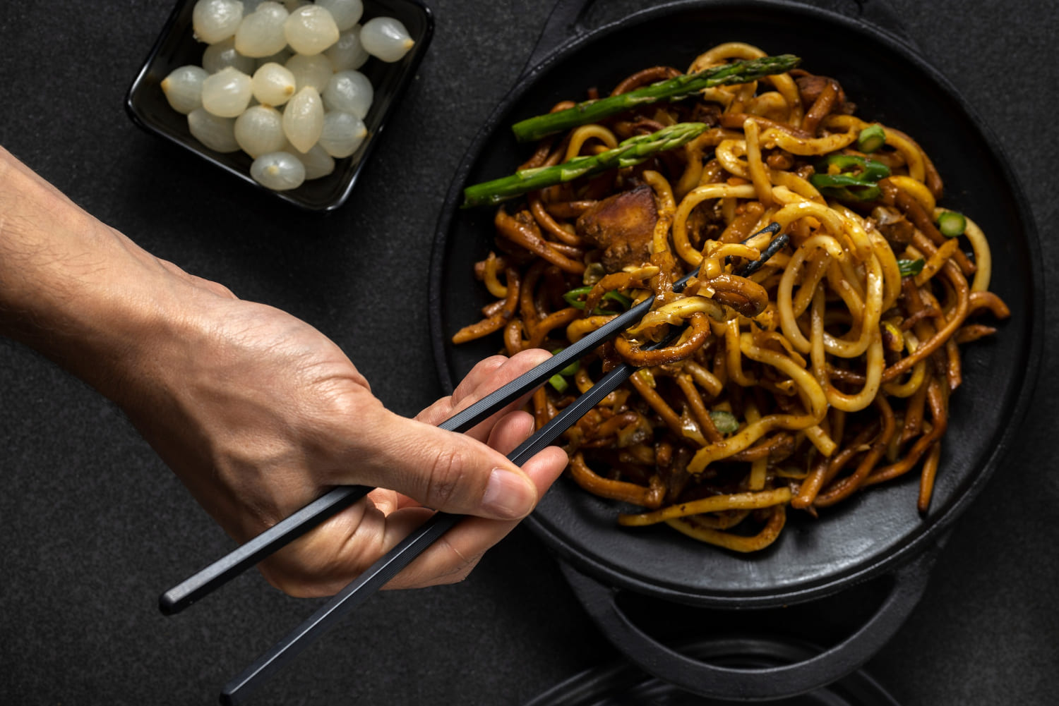hot pot di ramen con asparagi e ciotola di cipolline