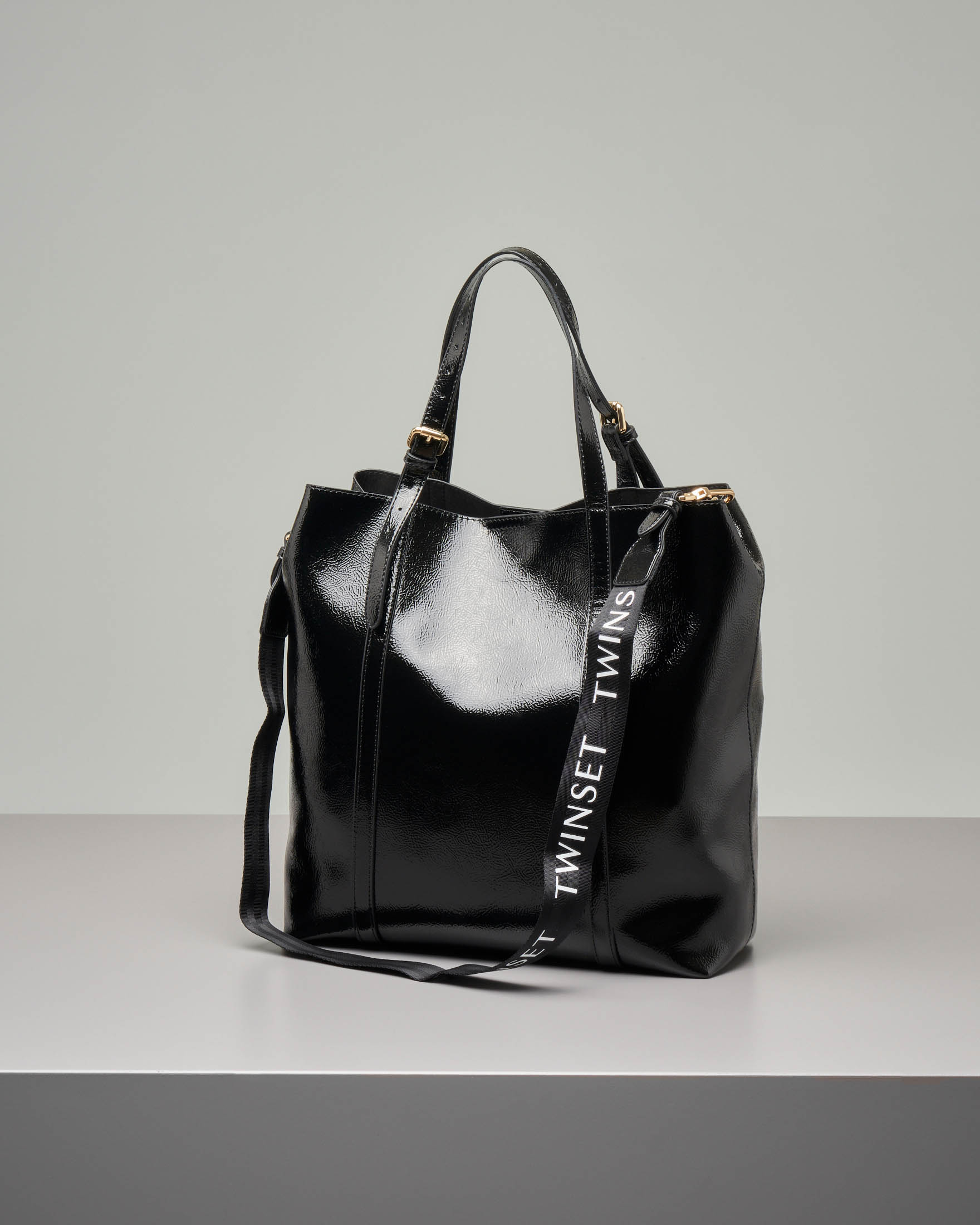 Shopping bag nera in ecopelle effetto vernice con tracolla in tessuto