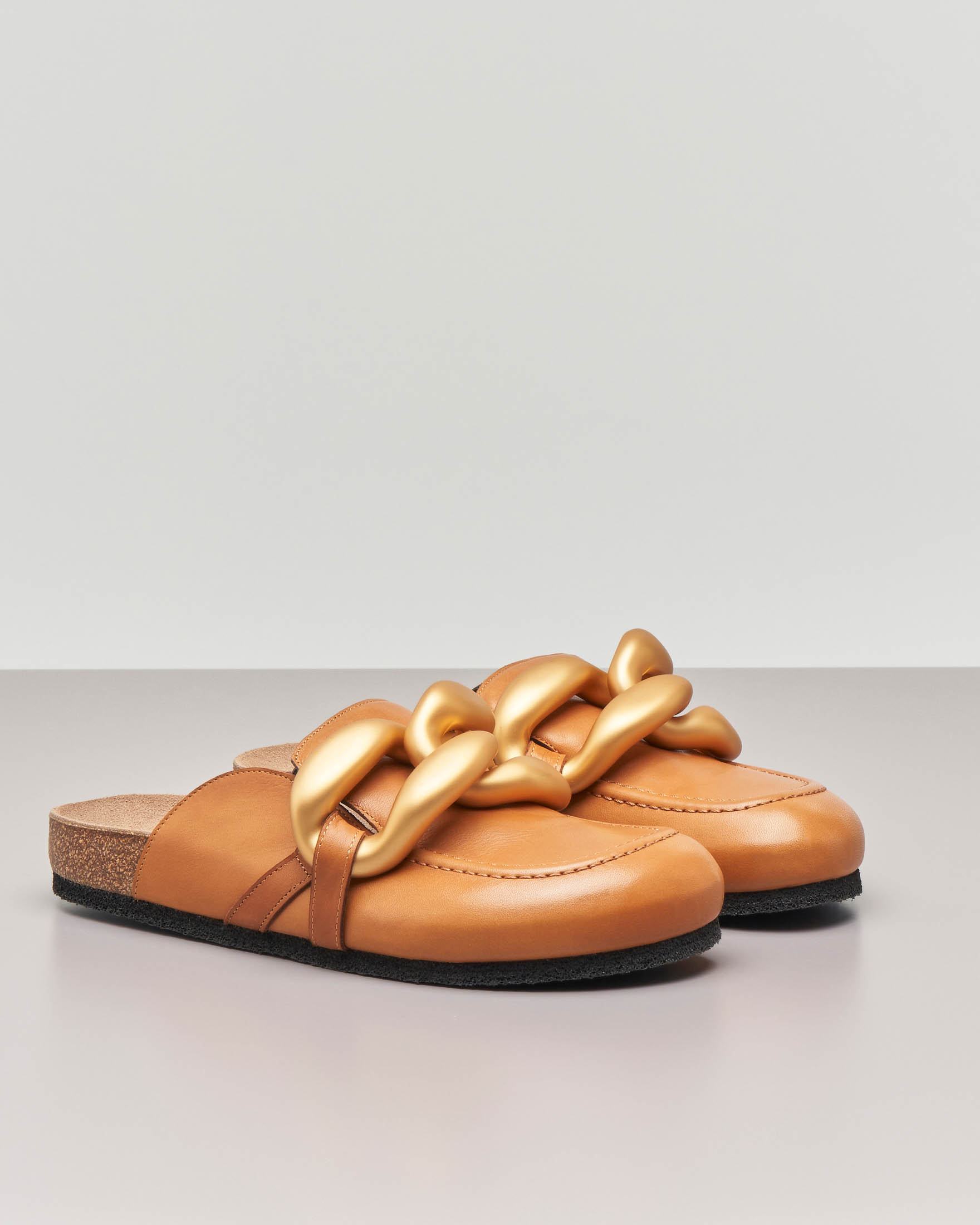 Slippers in pelle color cuoio con punta arrotondata e maxi catena dorata