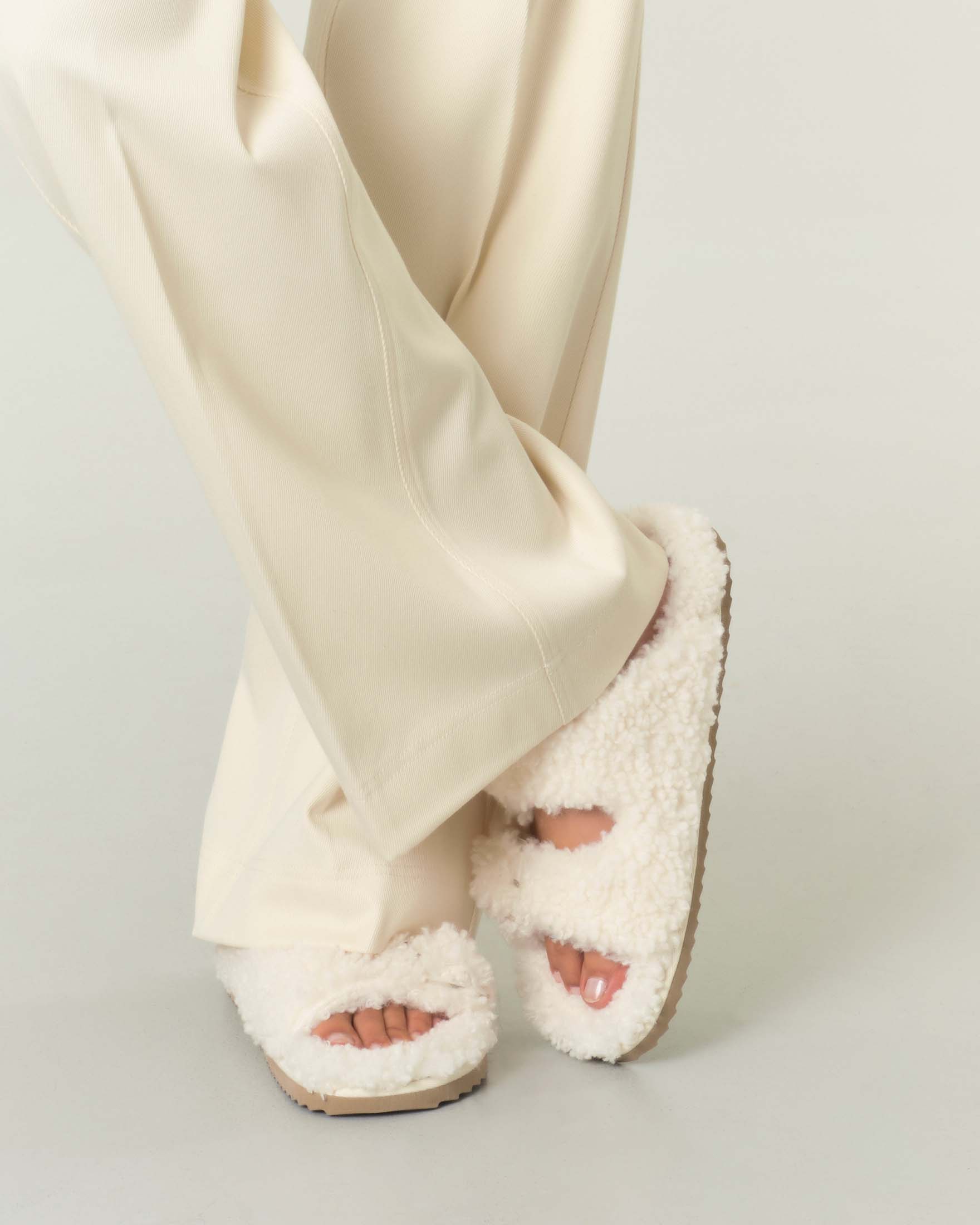 Slippers bianche in ecopelliccia effetto shearling con doppia fascetta e fibbie trasparenti image