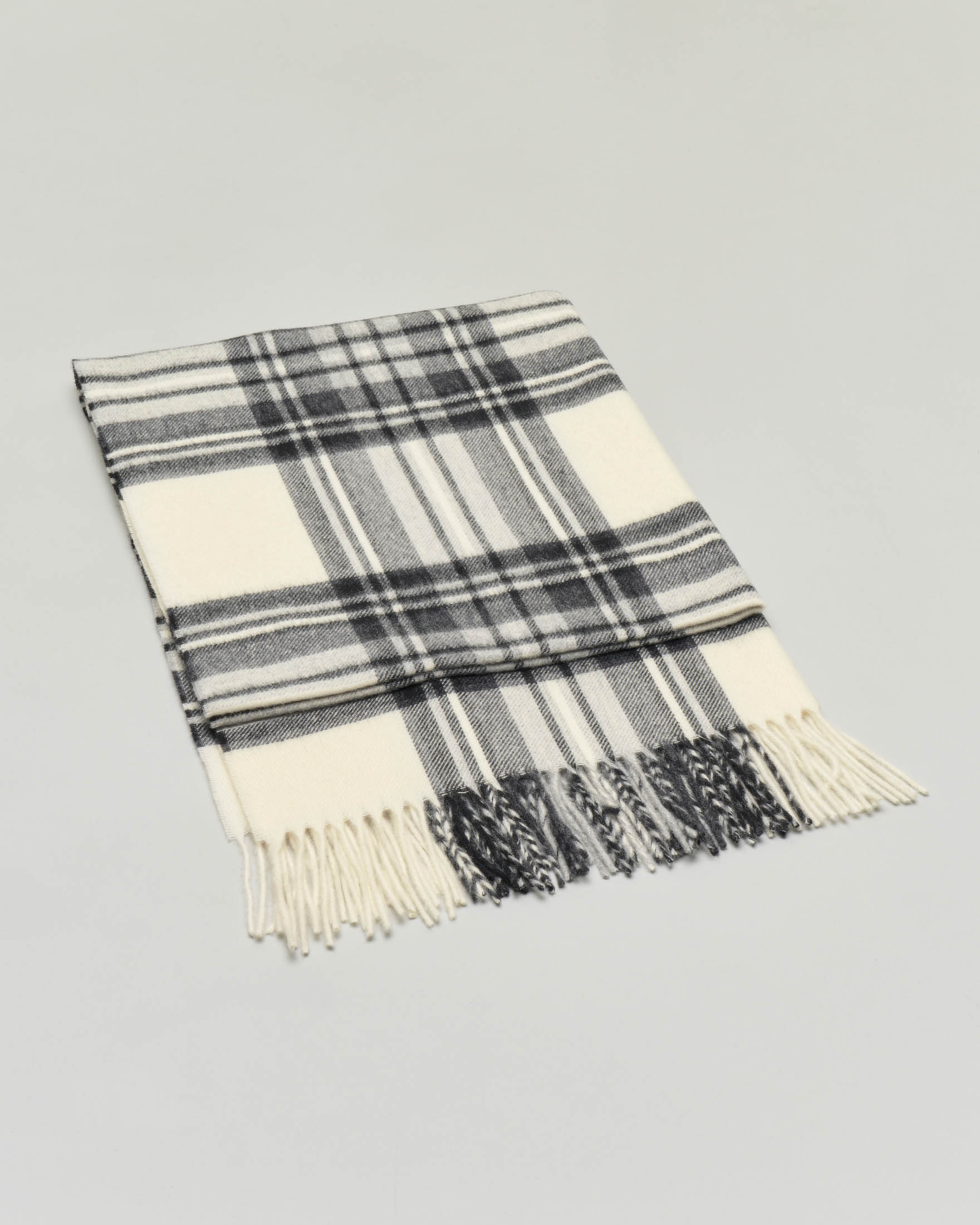 Sciarpa in lana merino color avorio a fantasia tartan nera con frange al fondo