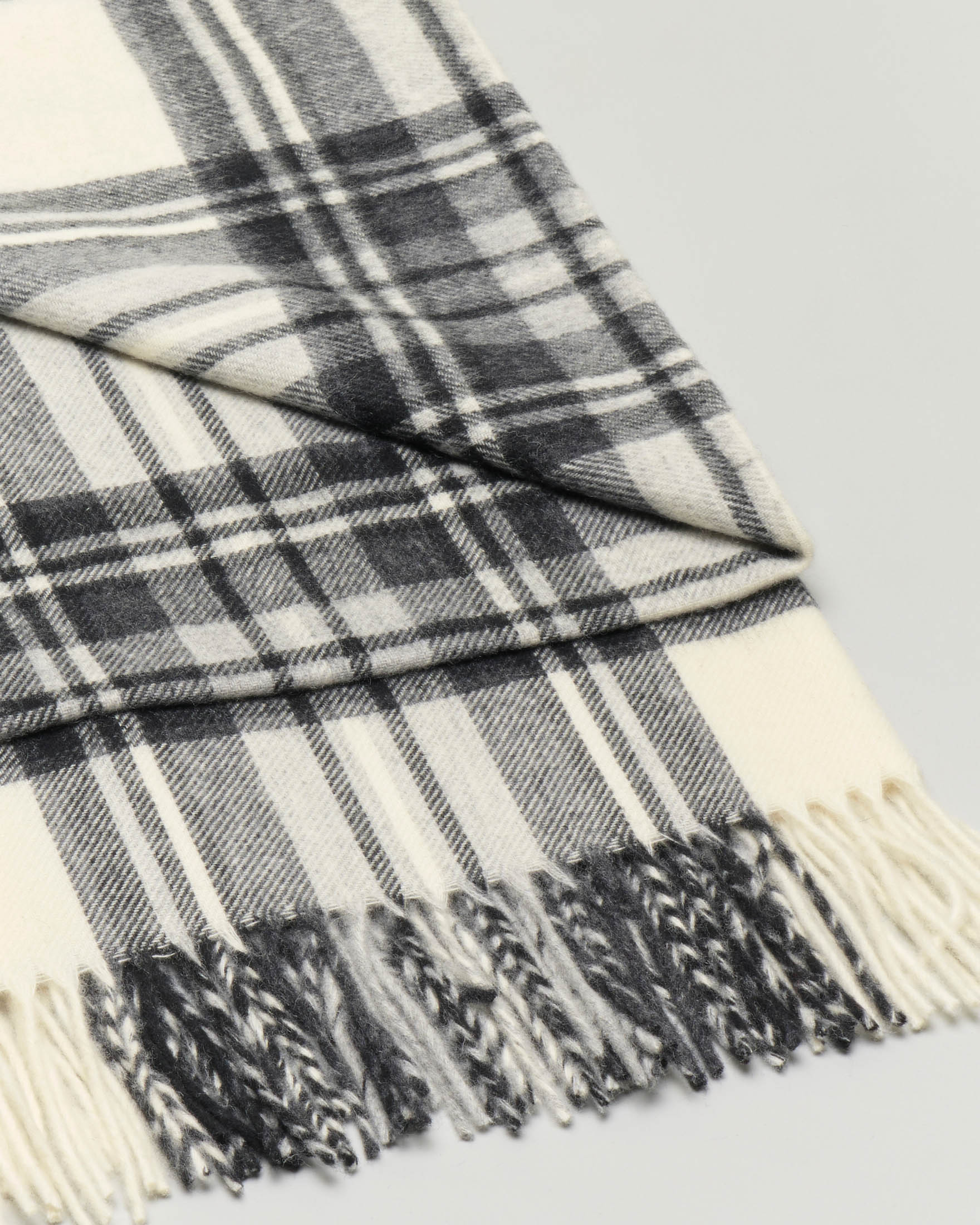 Sciarpa in lana merino color avorio a fantasia tartan nera con frange al fondo image