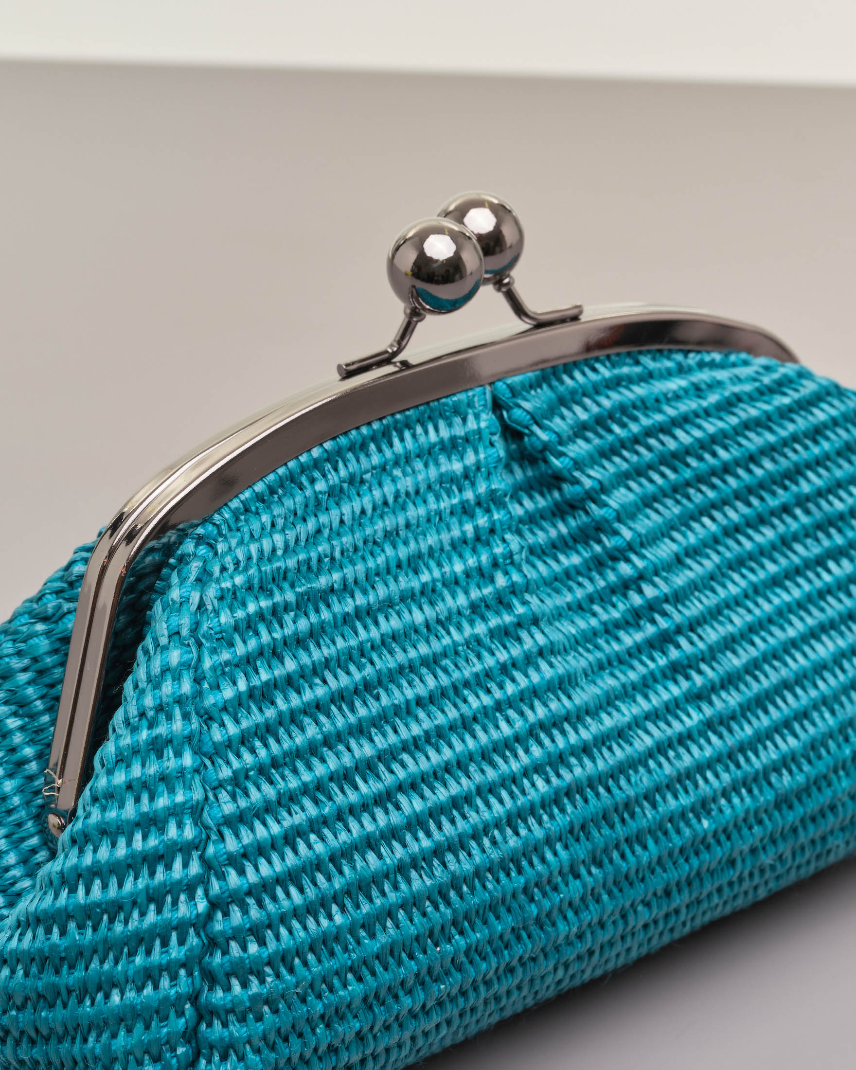 Borsa mini color ottanio in raffia con chiusura a clip in metallo con  tracolla a catena