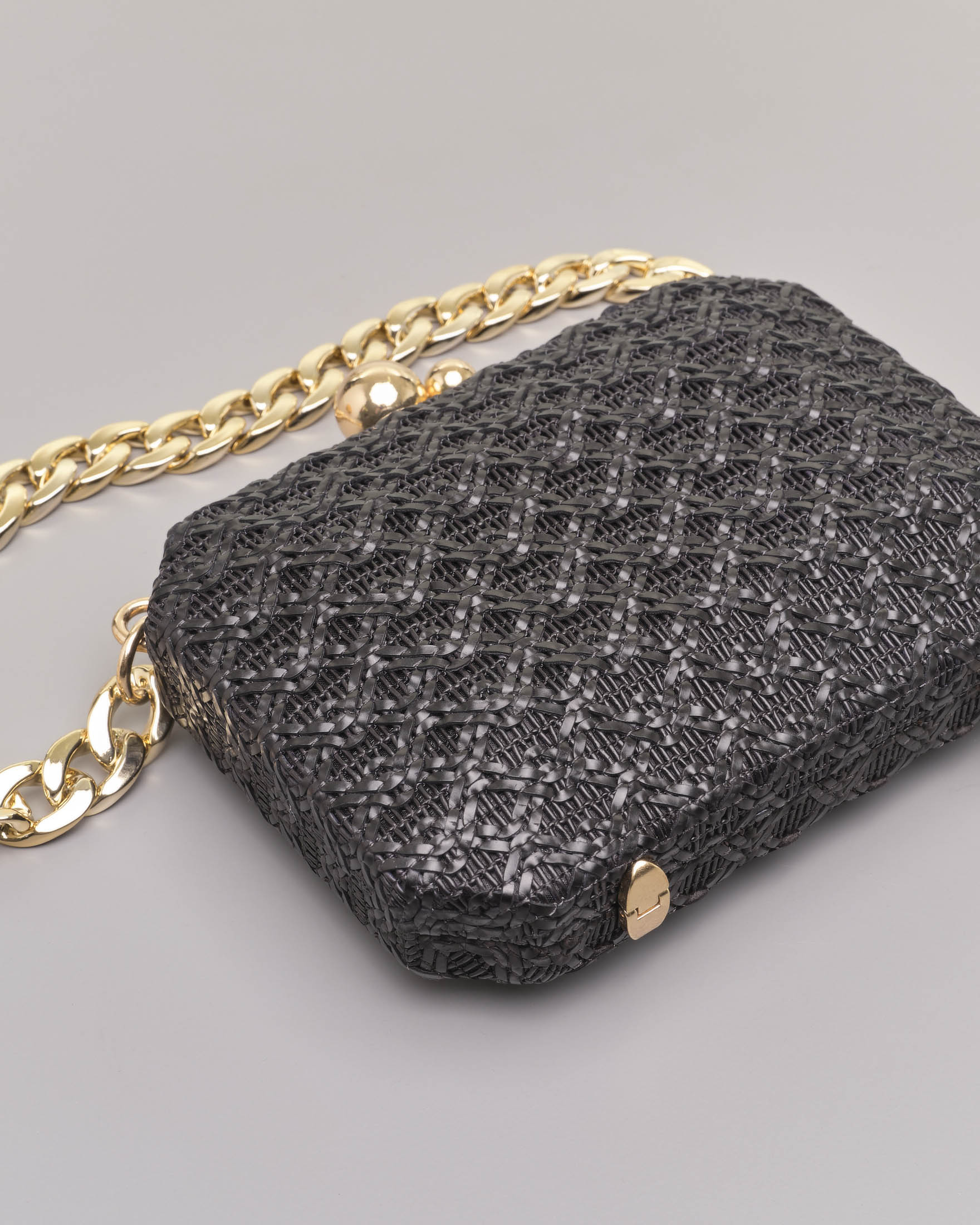 Clutch rigida ottagonale in raffia nera con chiusura a sfere dorate e e doppia tracolla a catena removibile image