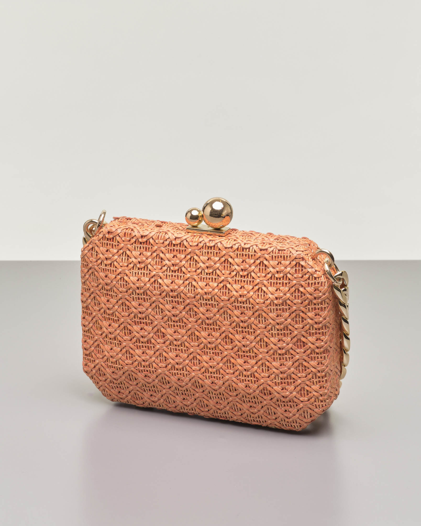 Clutch rigida ottagonale in raffia arancione con chiusura a sfere dorate e e doppia tracolla a catena removibile