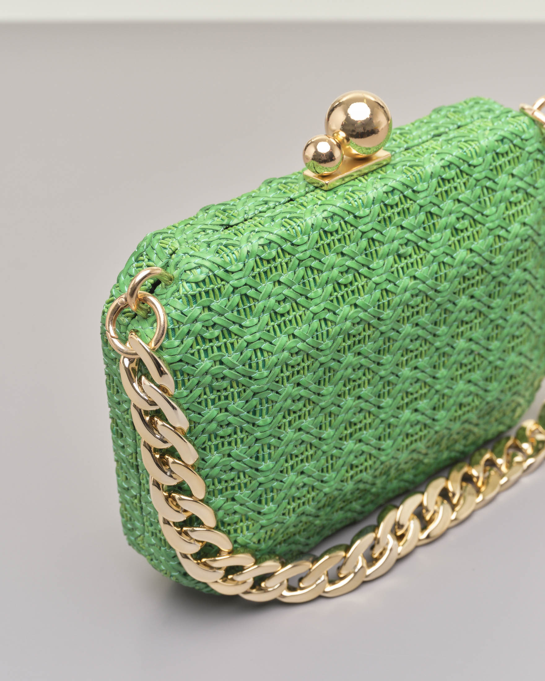 Clutch rigida ottagonale in raffia verde con chiusura a sfere dorate e e doppia tracolla a catena removibile image