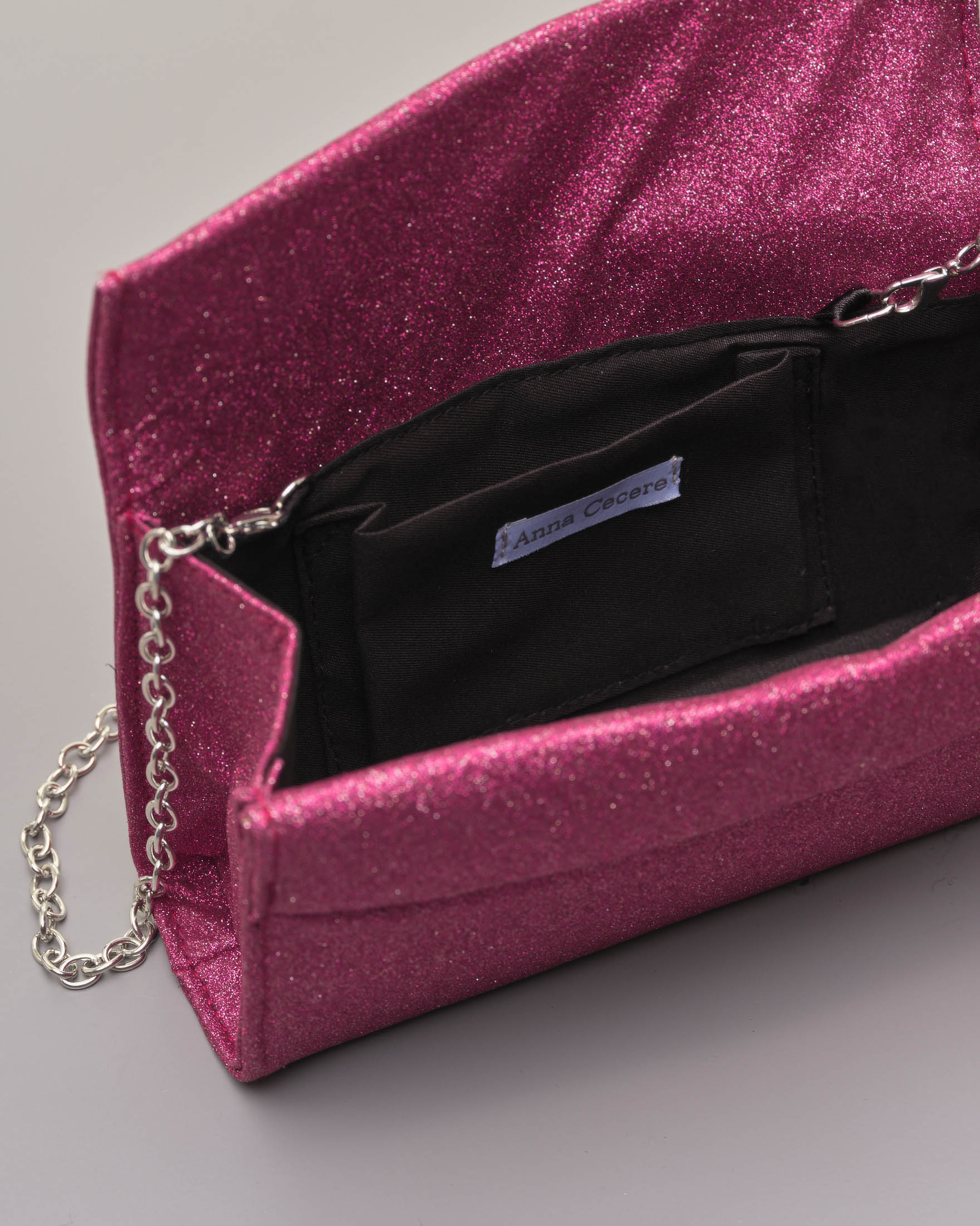 Pochette a base rigida in tessuto effetto glitter rosa fragola con piccola patta