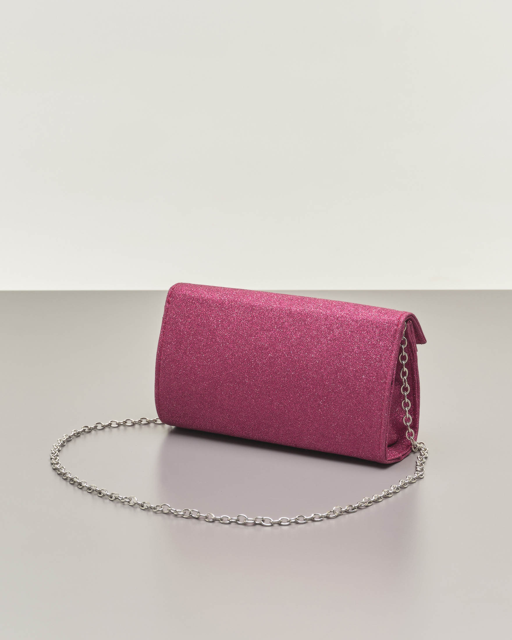 Pochette a base rigida in tessuto effetto glitter rosa fragola con piccola patta