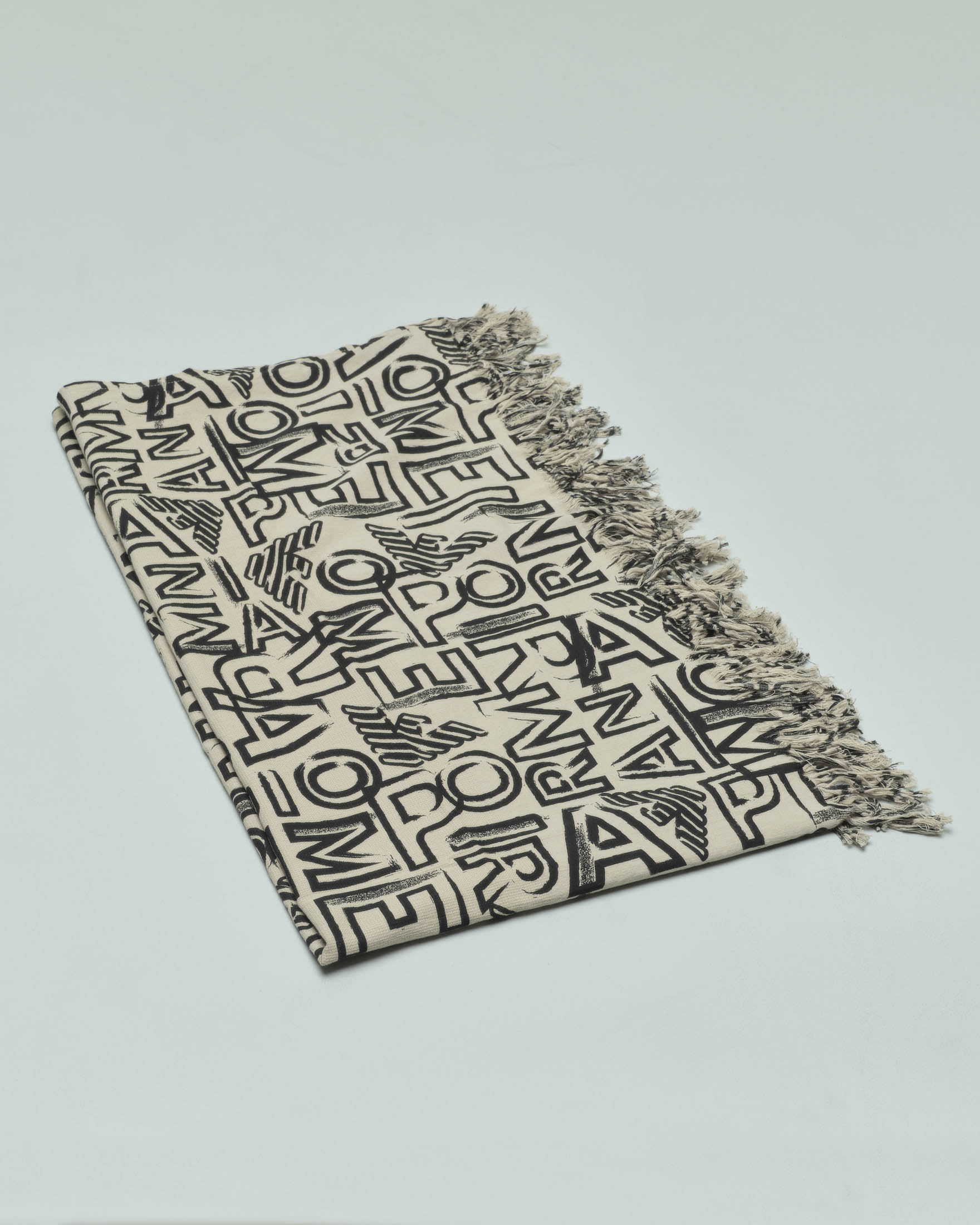 Telo mare color sabbia in cotone con motivo lettering nero all over e frange al fondo