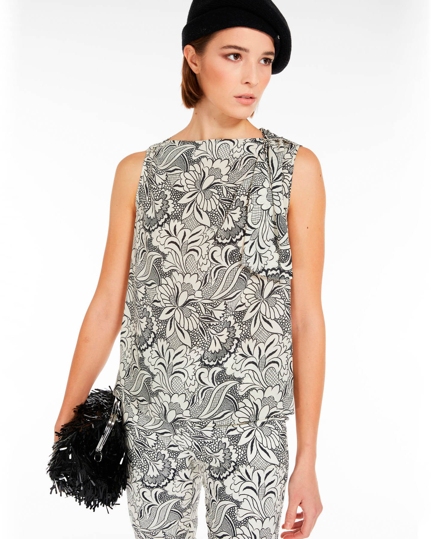 Blusa bianca senza maniche in crèpe de Chine di pura seta a fantasia floreale nera con drappeggio sulla spalla image