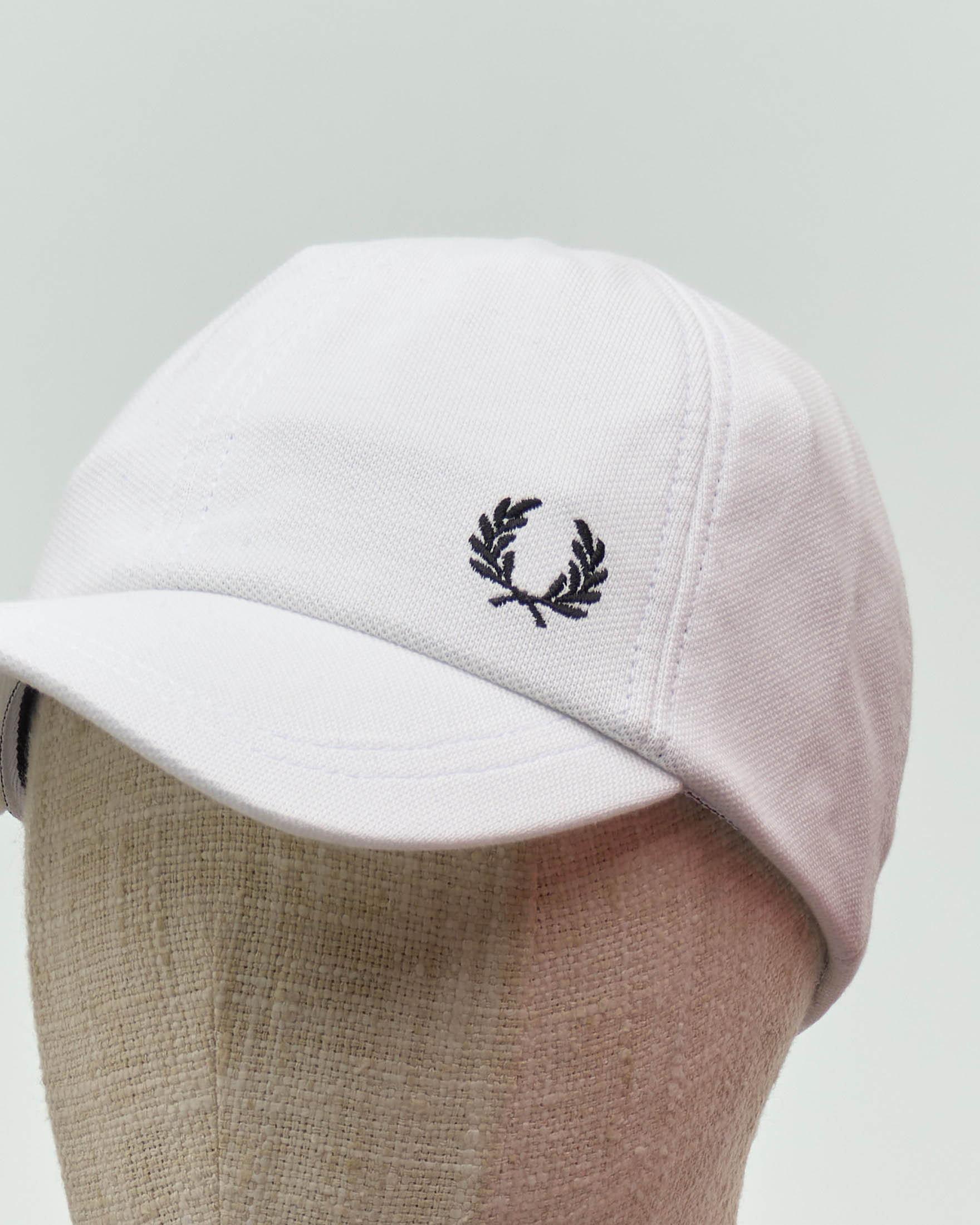Berretto Fred Perry bianco in piquè di cotone con frontino e logo corona d'alloro ricamato image