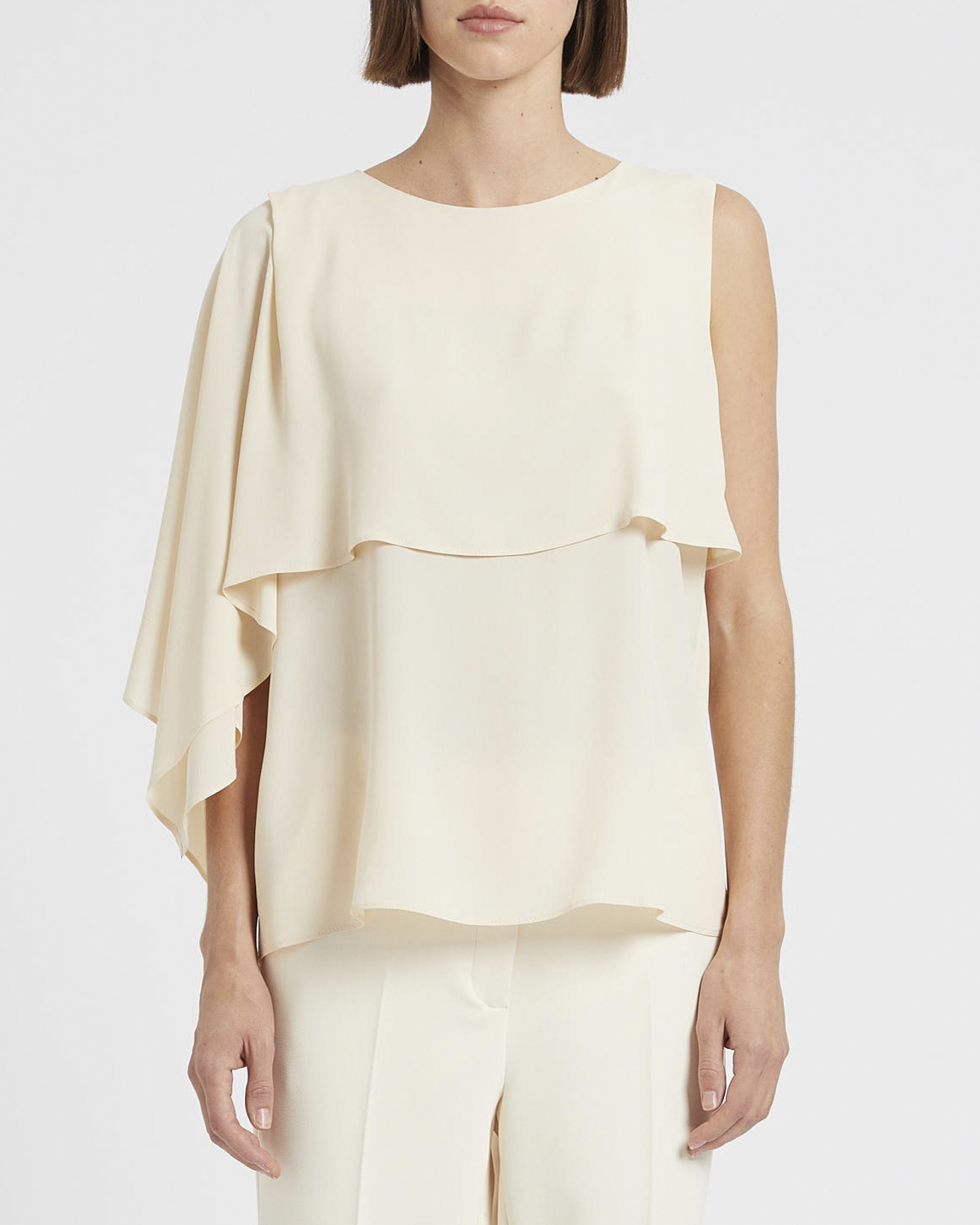 Blusa color avorio in misto crêpe di seta con mantellina asimmetrica con spacco laterale