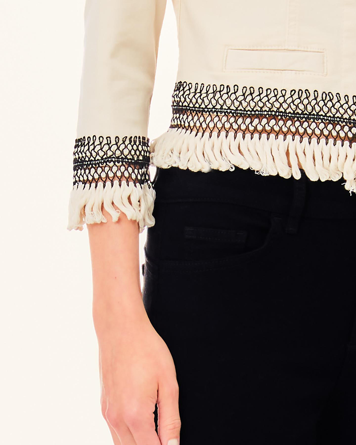 Giacca color crema in cotone senza colletto e frange applicate al fondo con ricami traforati image