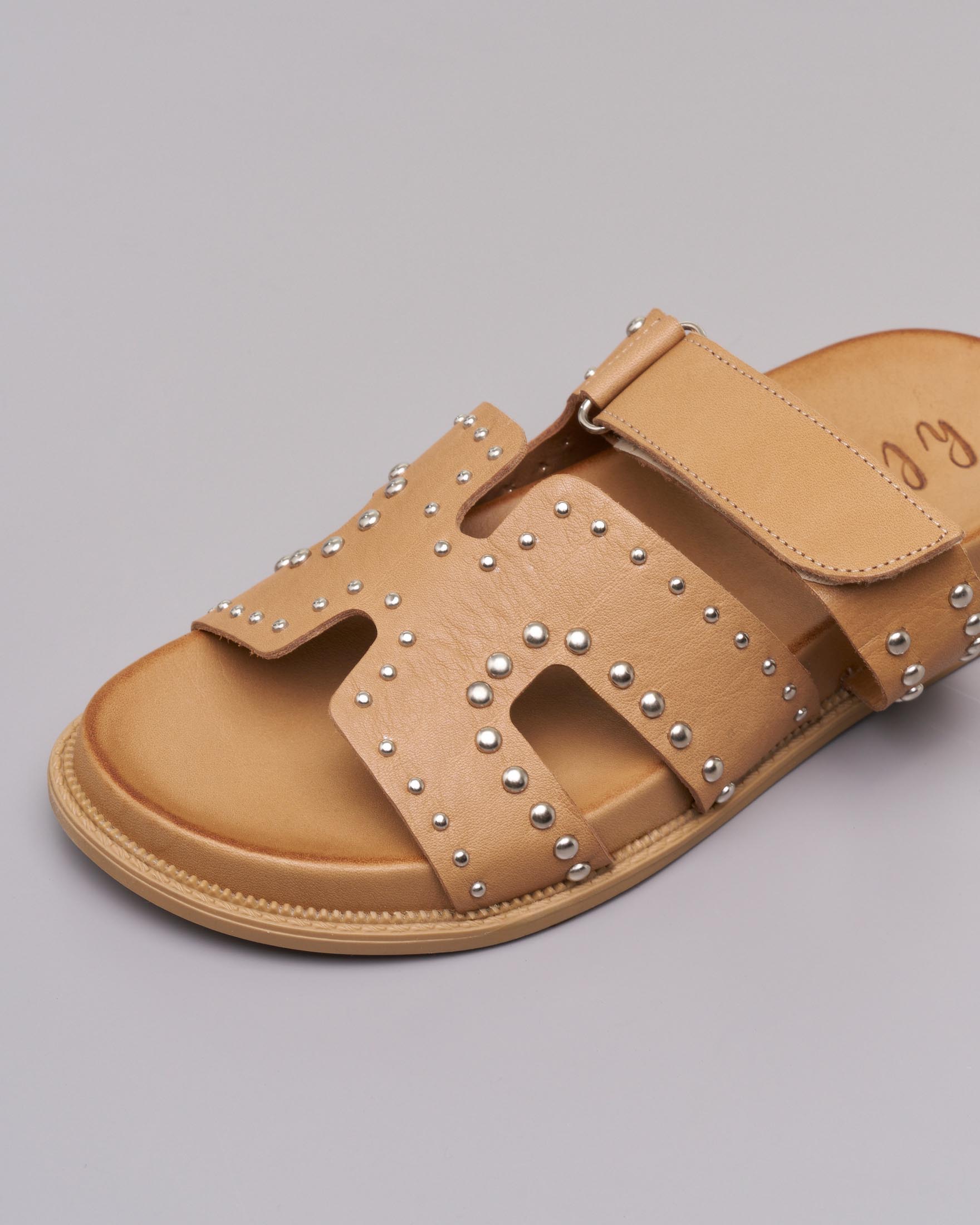 Sandali bassi color cuoio in pelle con borchiette argento applicate sulla fibbia con chiusura a strappo image