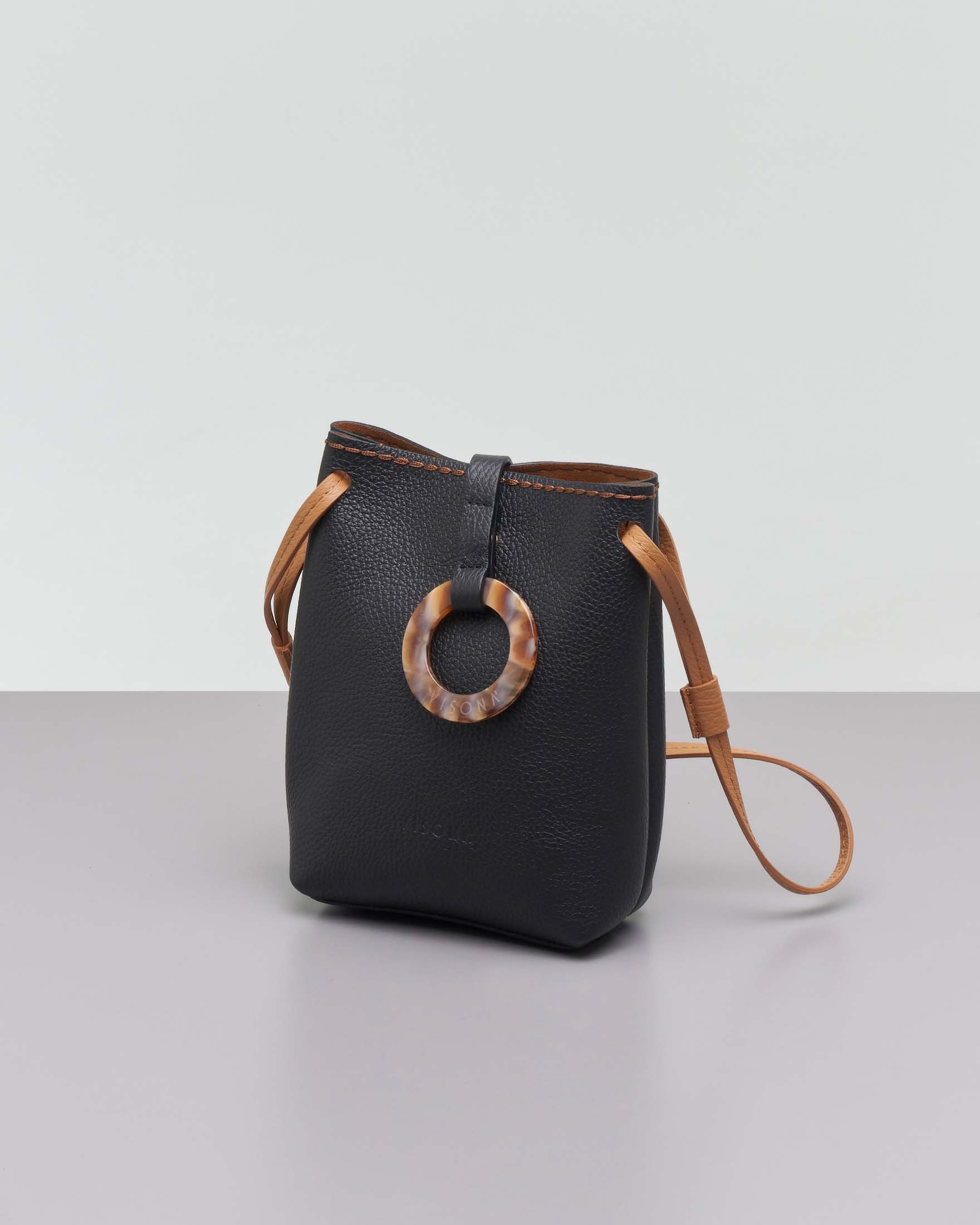 Mini bag in pelle martellata nera con tracolla color cuoio e chiusura ad anello in osso