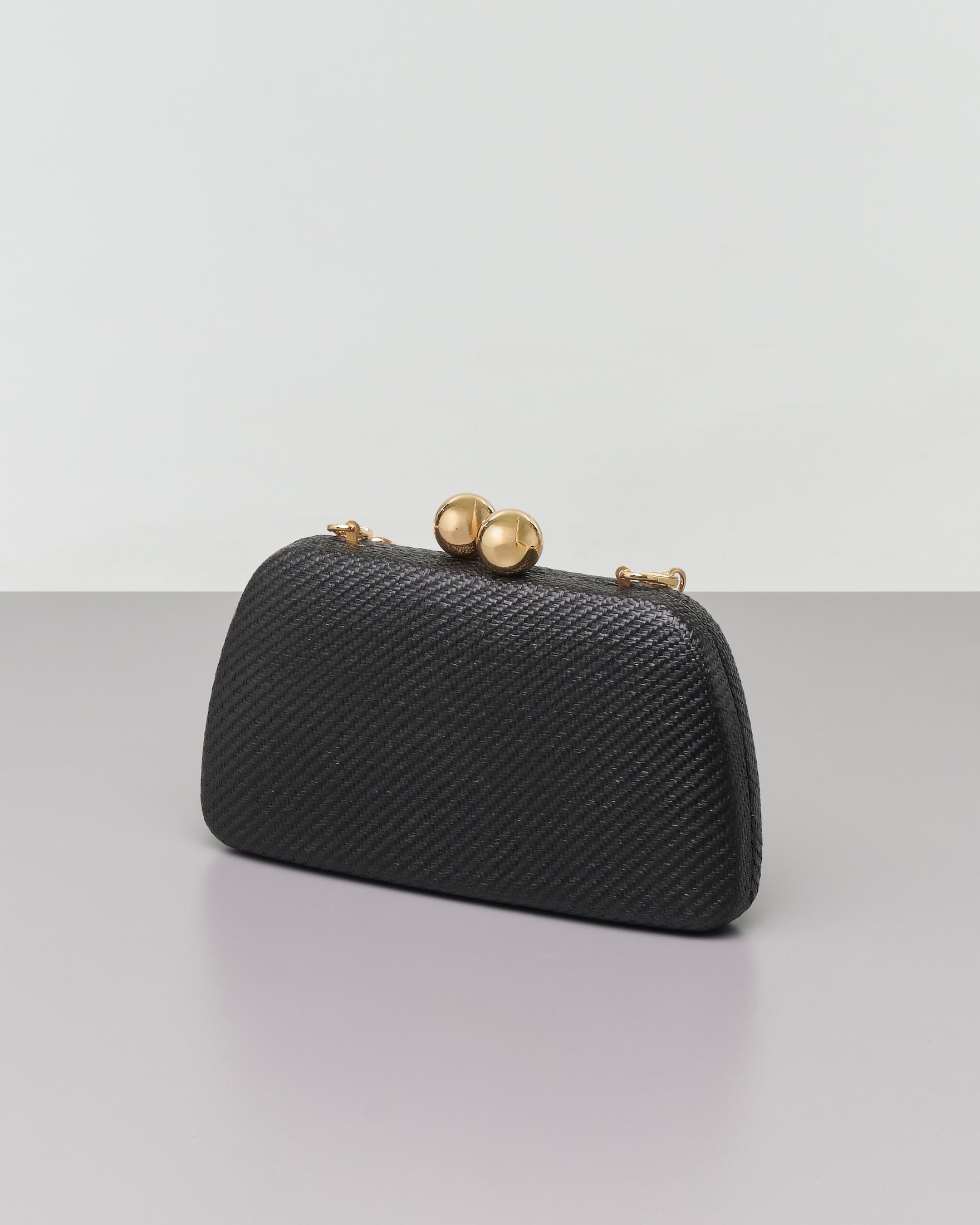 Clutch rigida in raffia nera con chiusura a scatto a sfere corate e tracolla catena in resina