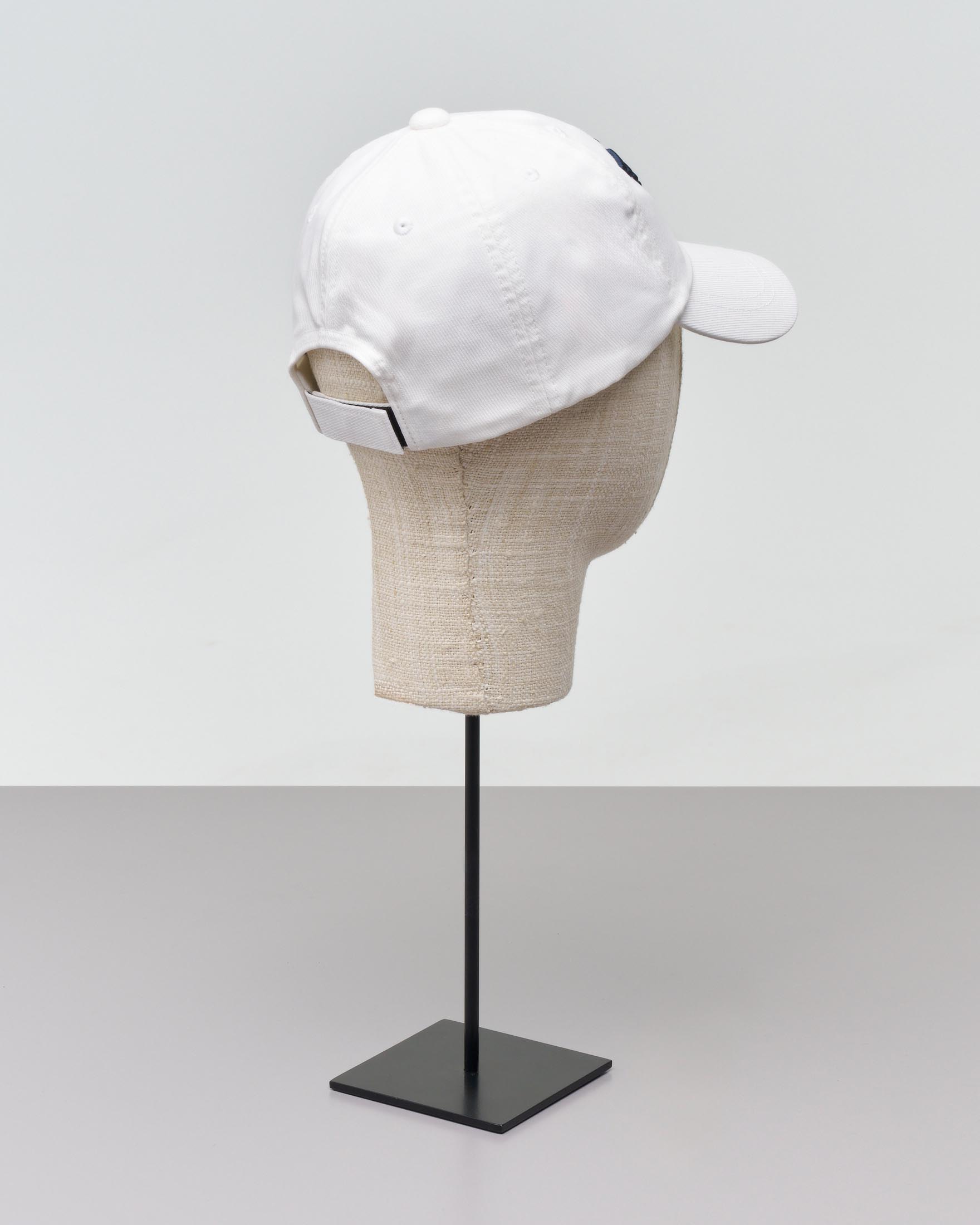 Berretto bianco Emporio Armani Junior in cotone con frontino e logo aquila blu in rilievo davanti 