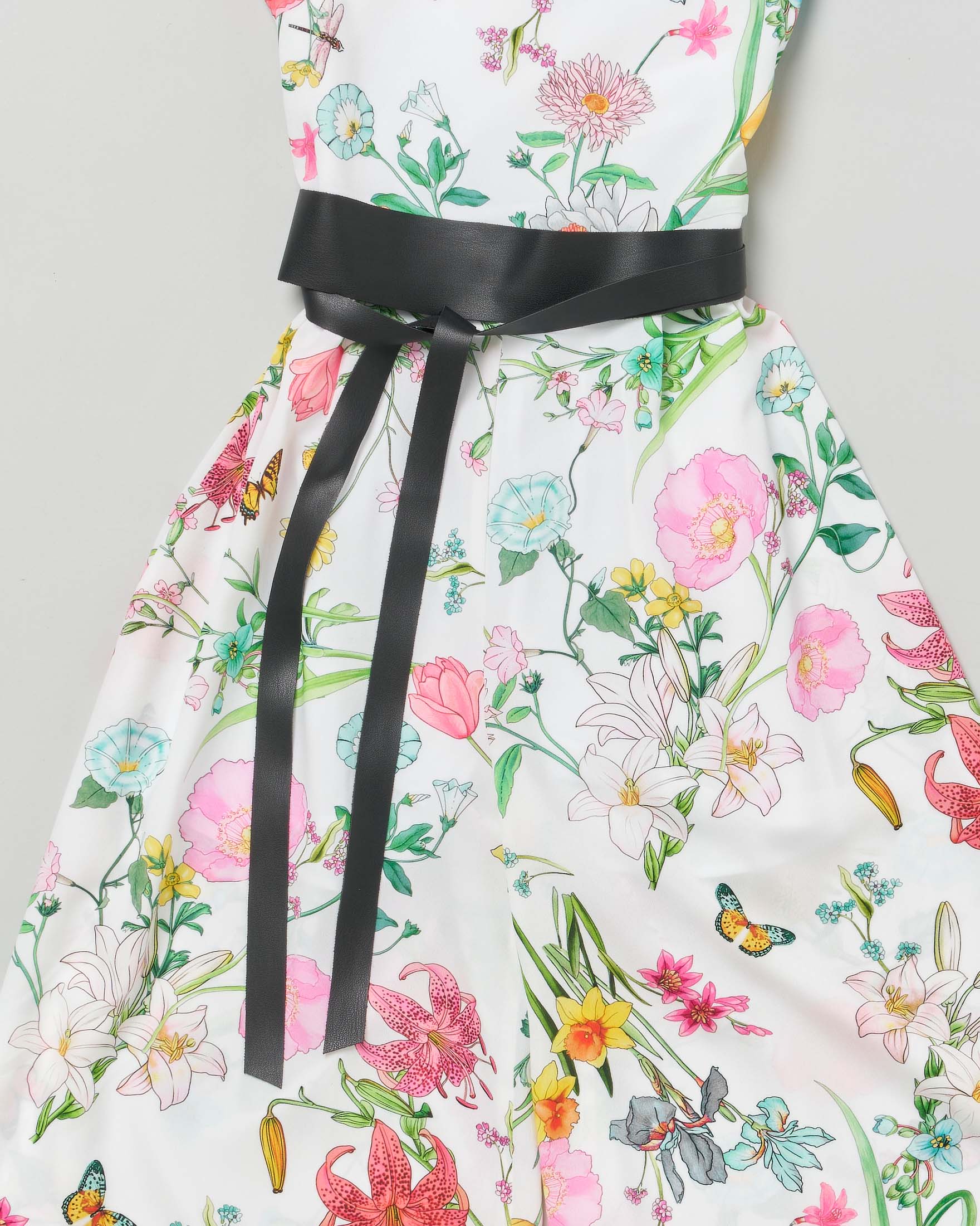 Tuta bianca smanicata in fantasia floreale con pantalone a palazzo e fusciacca in ecopelle nera  image