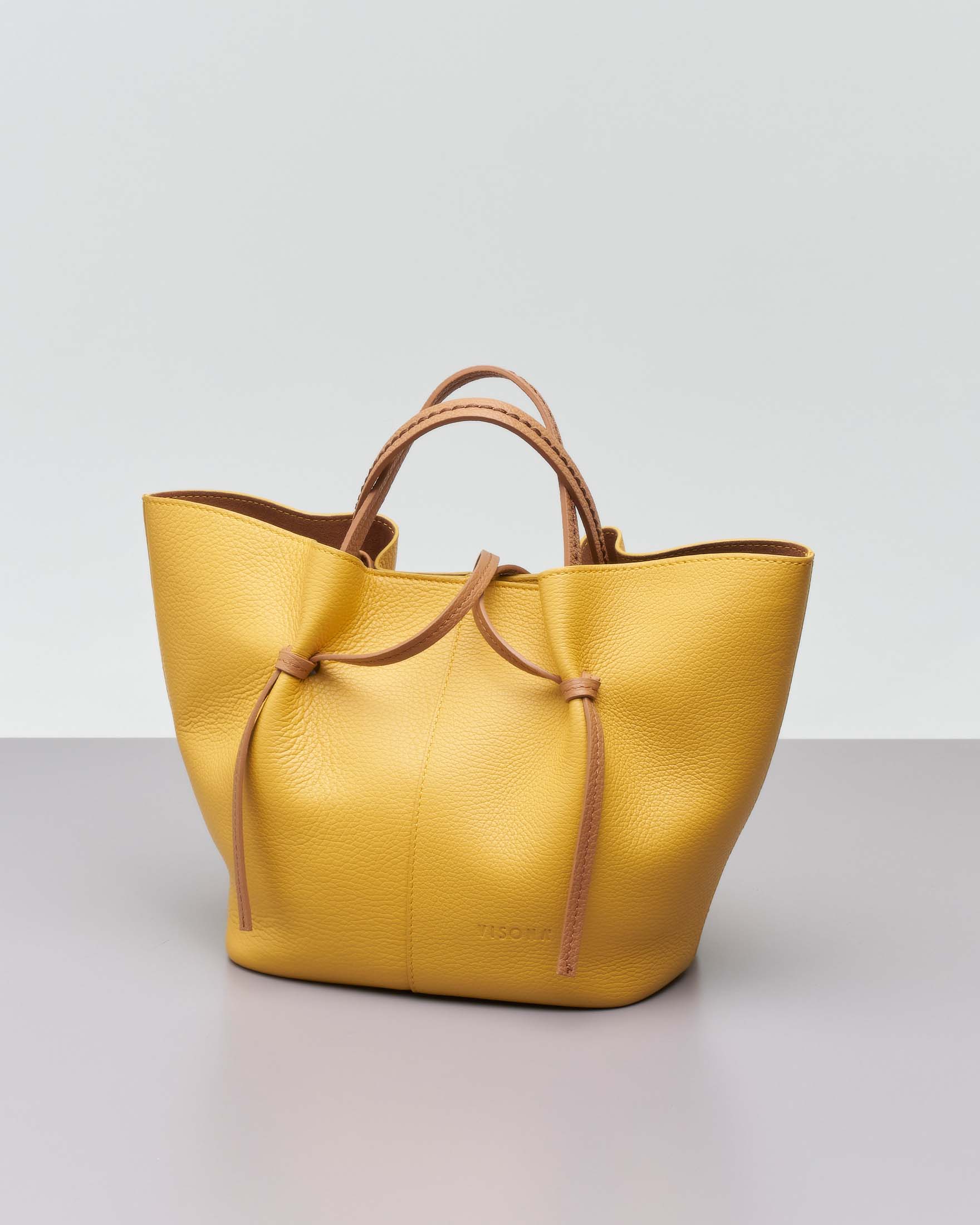 Borsa a mano gialla in pelle martellata con manici a contrasto e pochette color cuoio