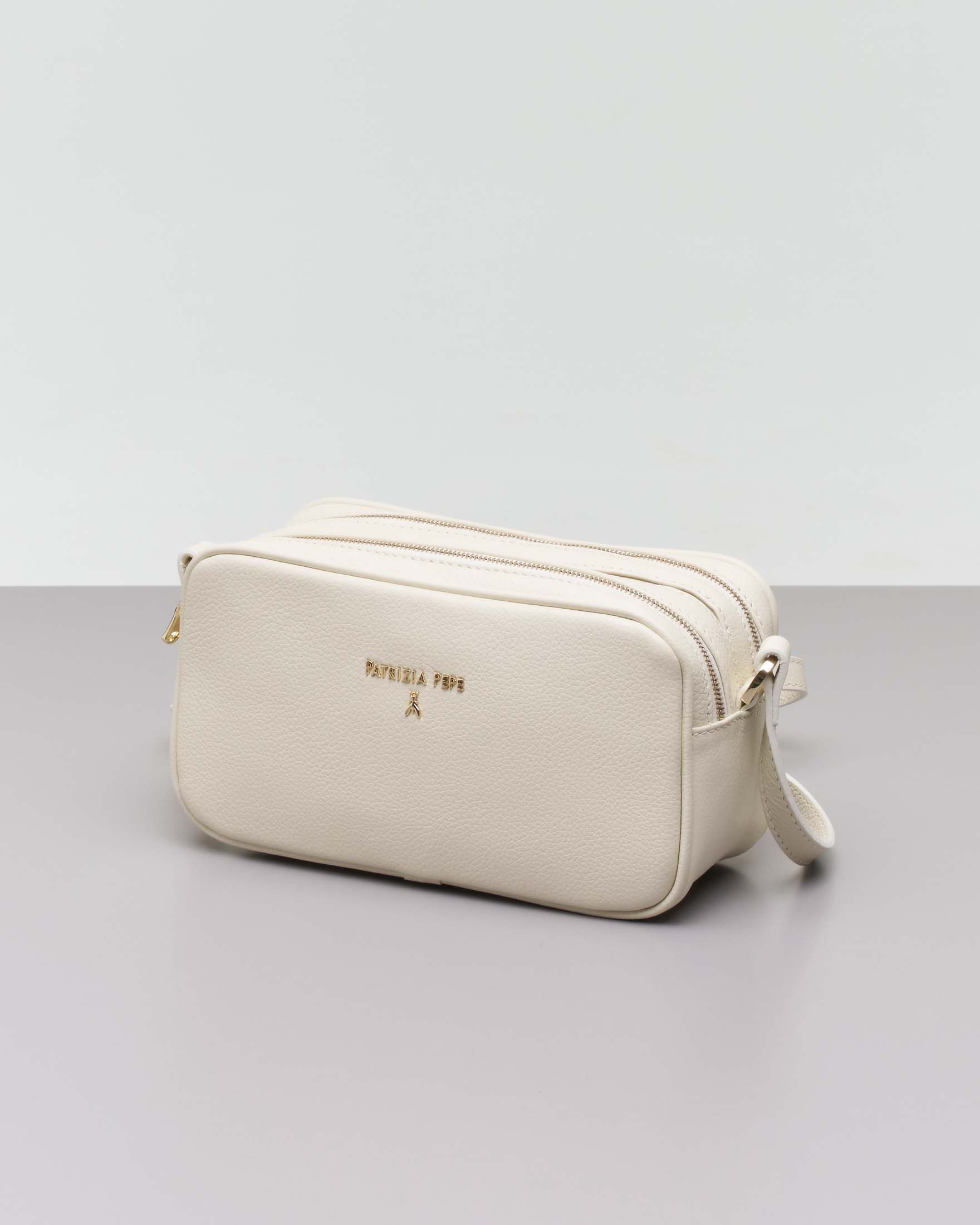 Cross bag color panna dalla linea allungata in pelle con scritta logo dorata sul davanti