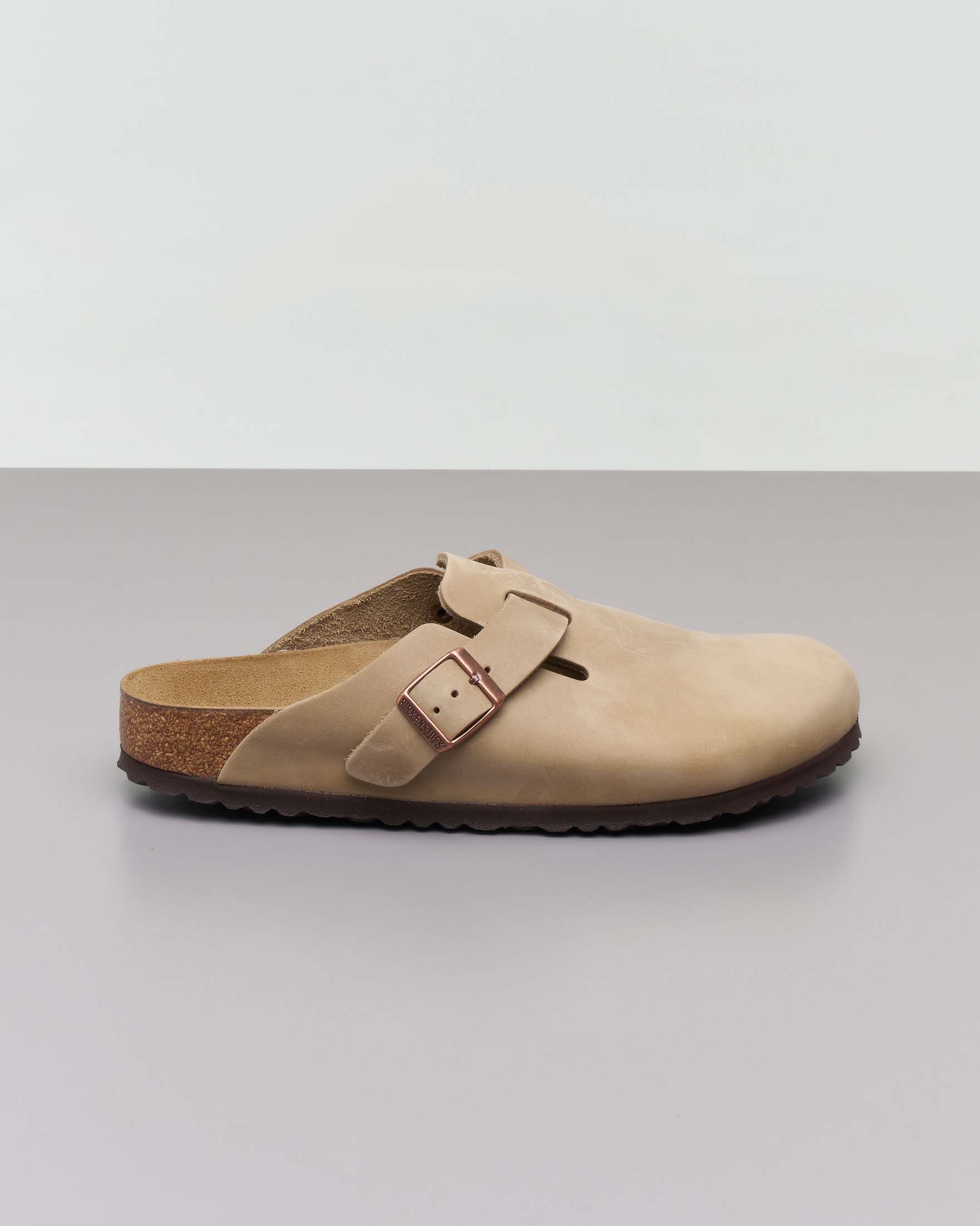 Sabot Boston Birkenstock in pelle oliata color sabbia con fascetta laterale e fibbia tono su tono con logo