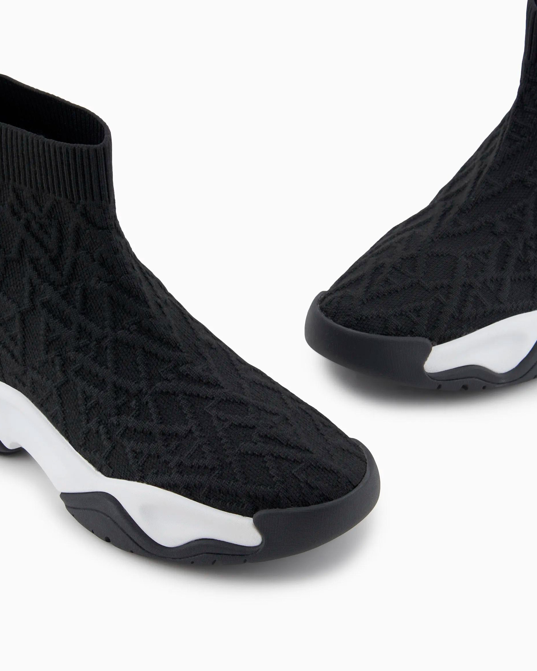 Sneaker in maglia nera con scritta logo all over a rilievo con suola in gomma bicolore