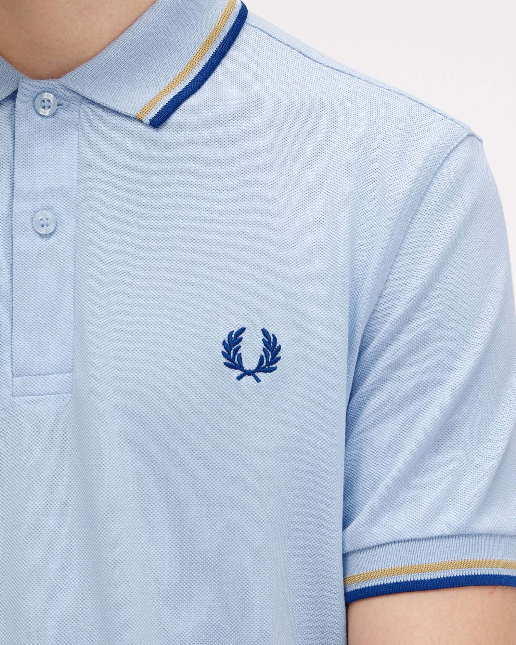 Polo azzurra mezza manica con bordino blu royal e giallo