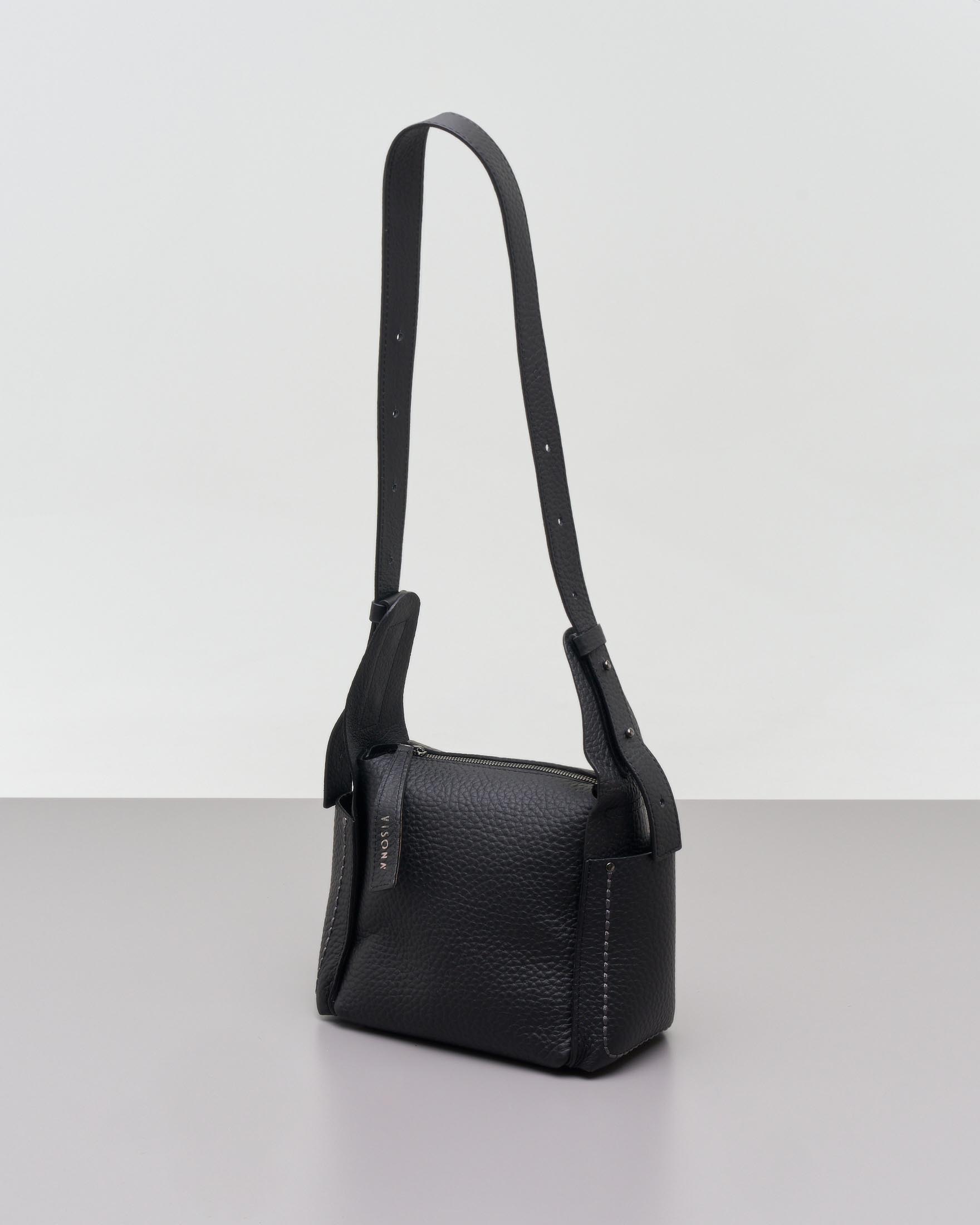 Cross bag nera in pelle martellata con tasche laterali impunturate a contrasto di colore