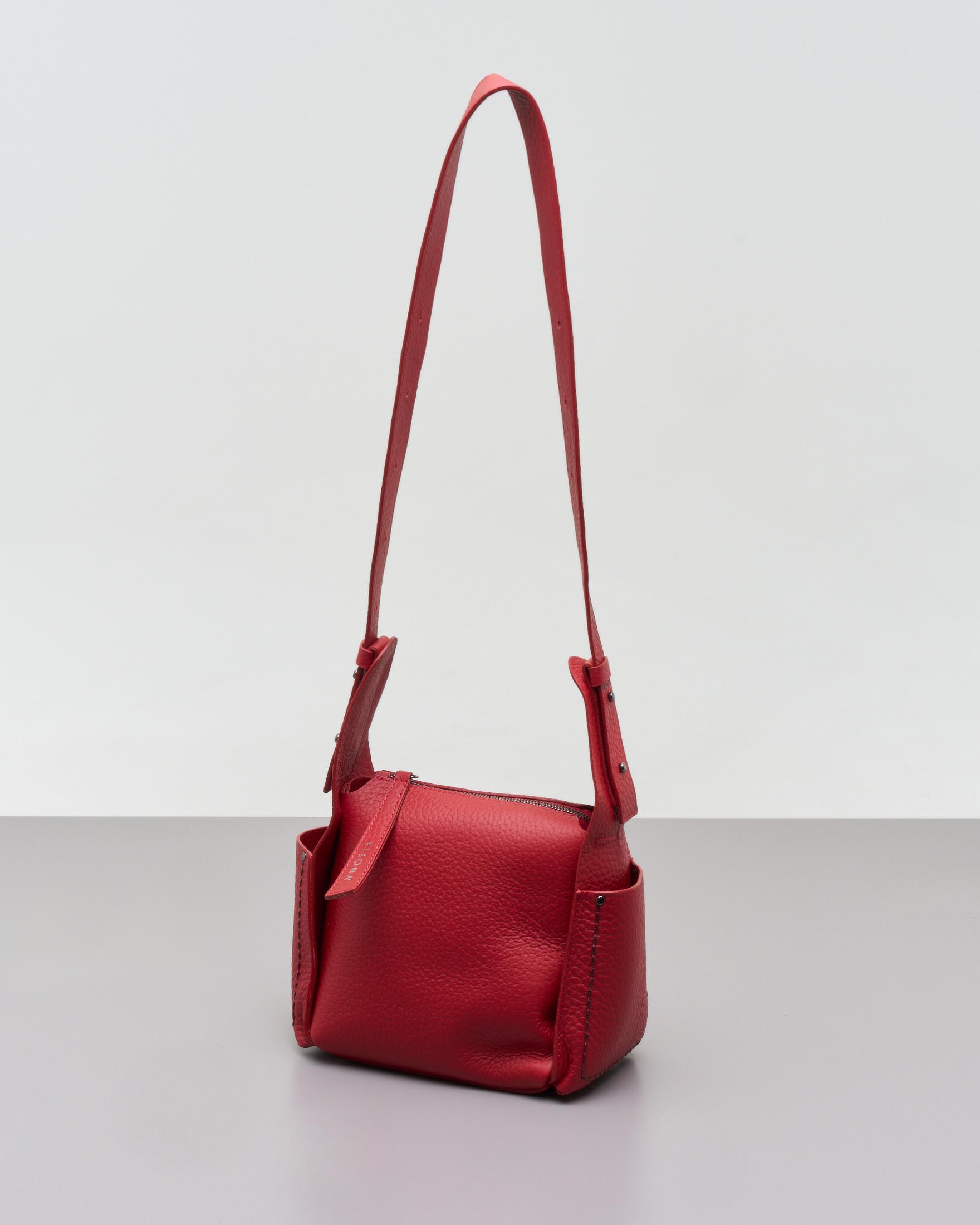 Cross bag rossa in pelle martellata con tasche laterali impunturate a contrasto di colore