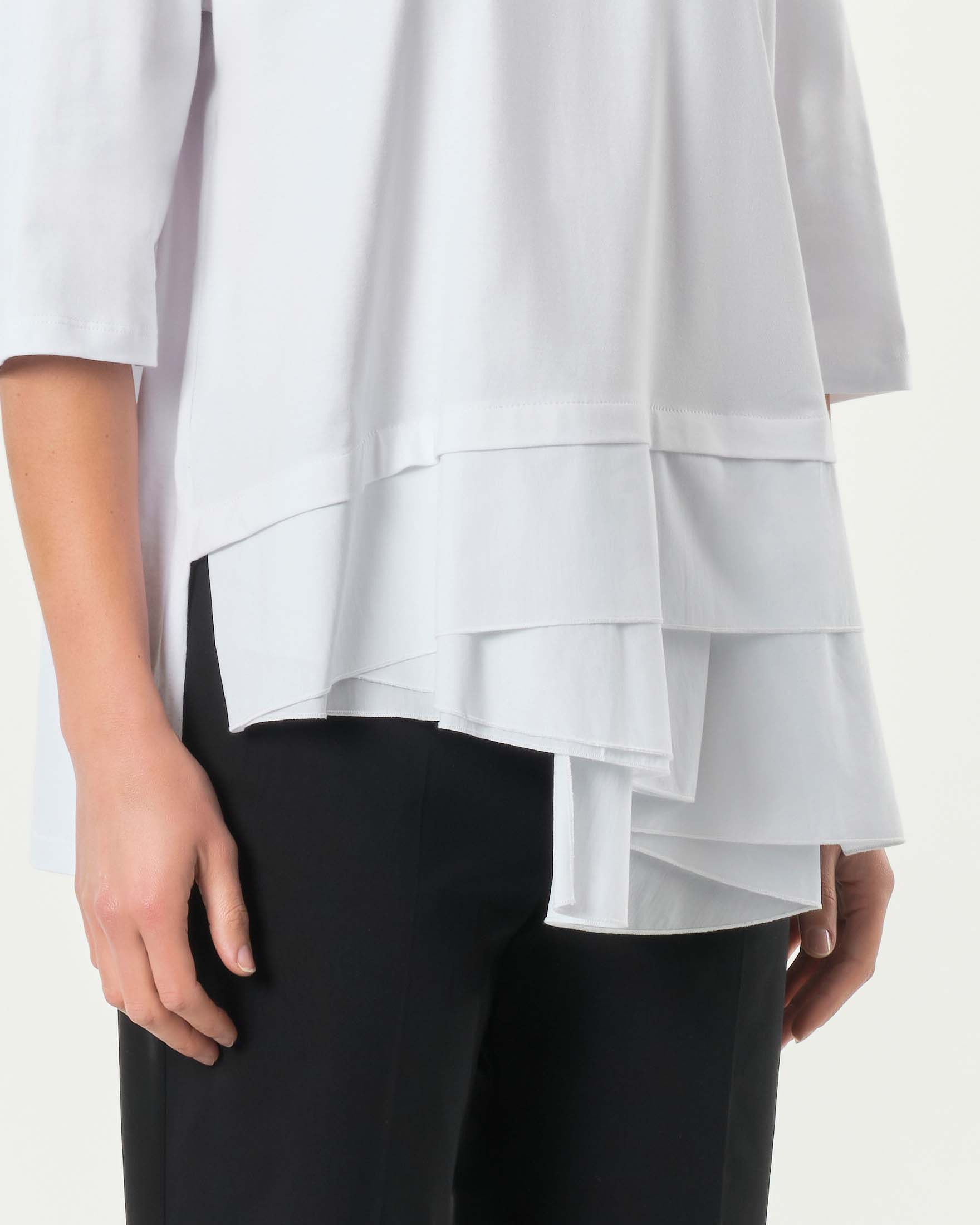 T-shirt bianca in cotone stretch con maniche tre quarti e balze asimmetriche al fondo