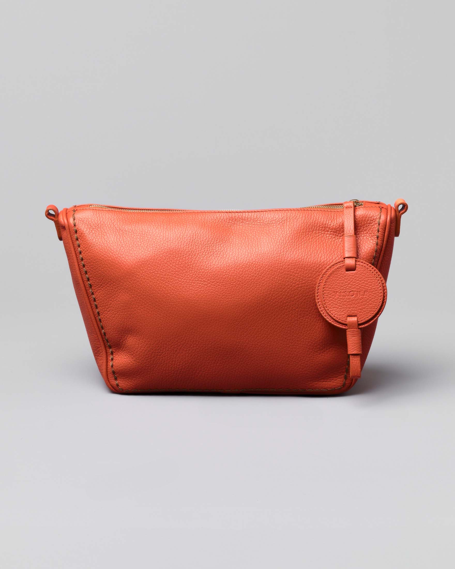 Borsa arancione in pelle martellata a trapezio con medaglione logato tono su tono